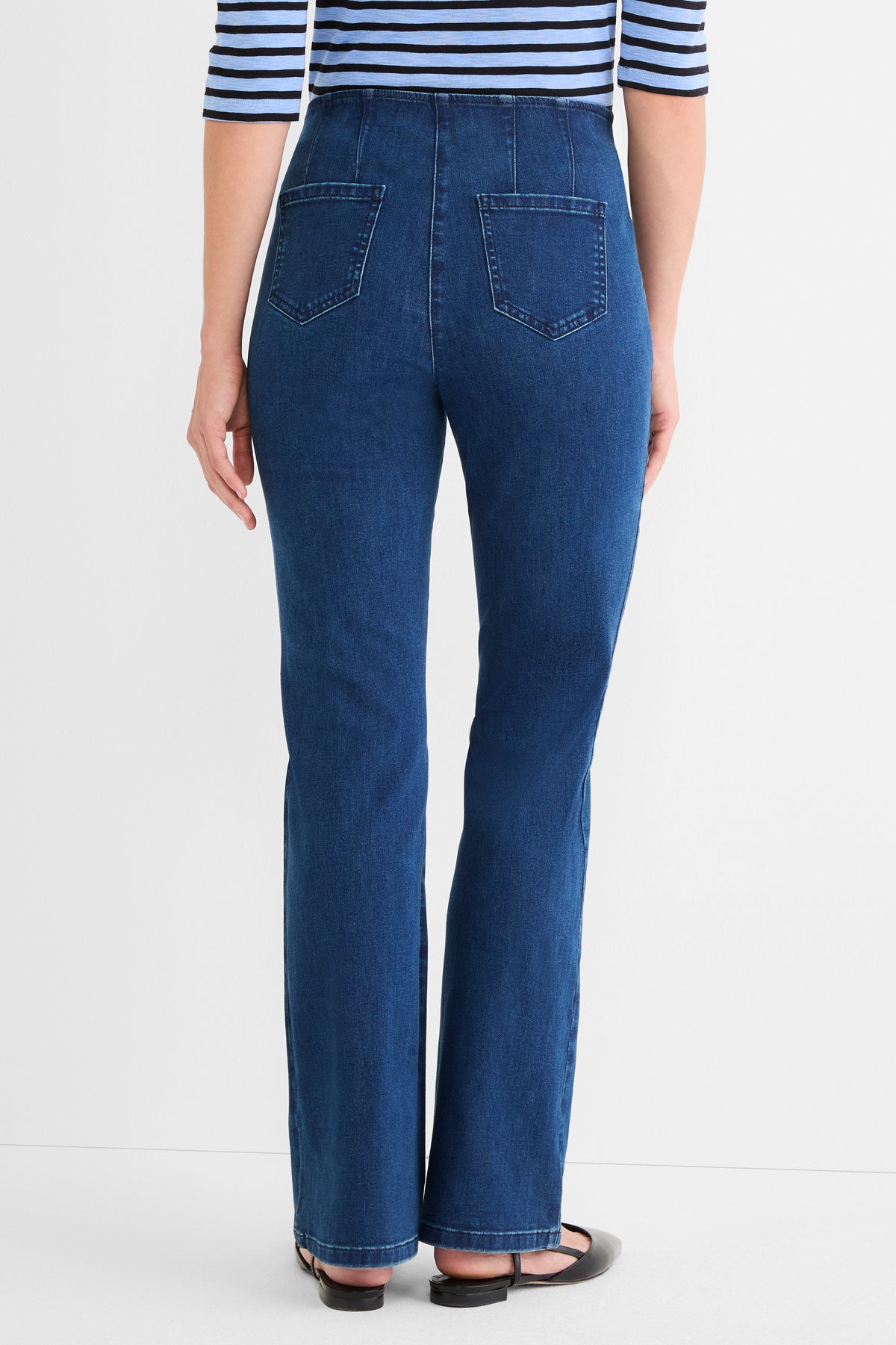 These high-waisted, dark wash blue jeans have a slim cut, back paneling, and square patch pockets.