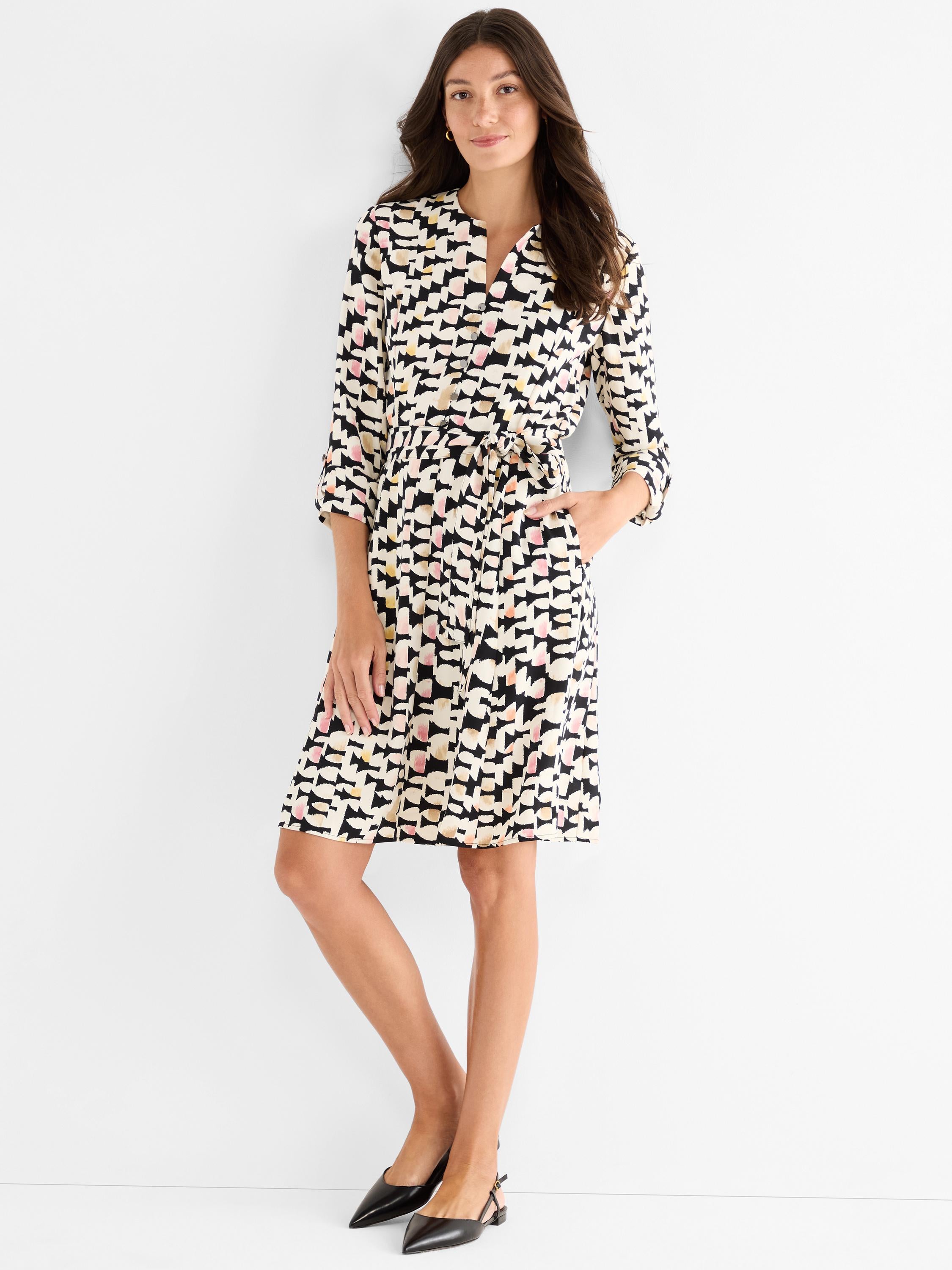 This colorful abstract print shirtdress has a tie belt waist, 3/4 sleeves, and a knee-length A-line fit.
