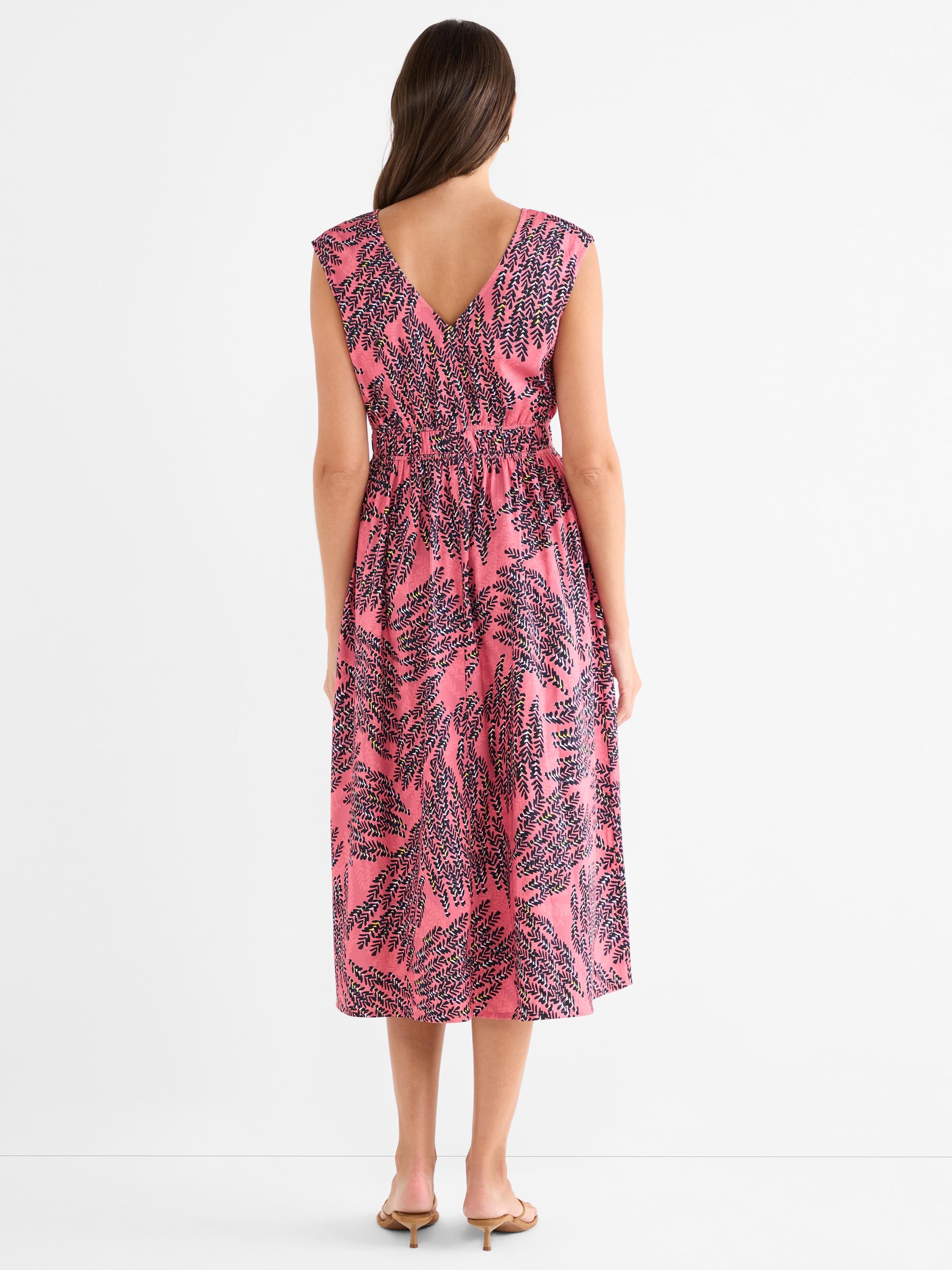 This pink patterned sleeveless midi dress features a V-back and a fitted smocked waist.
