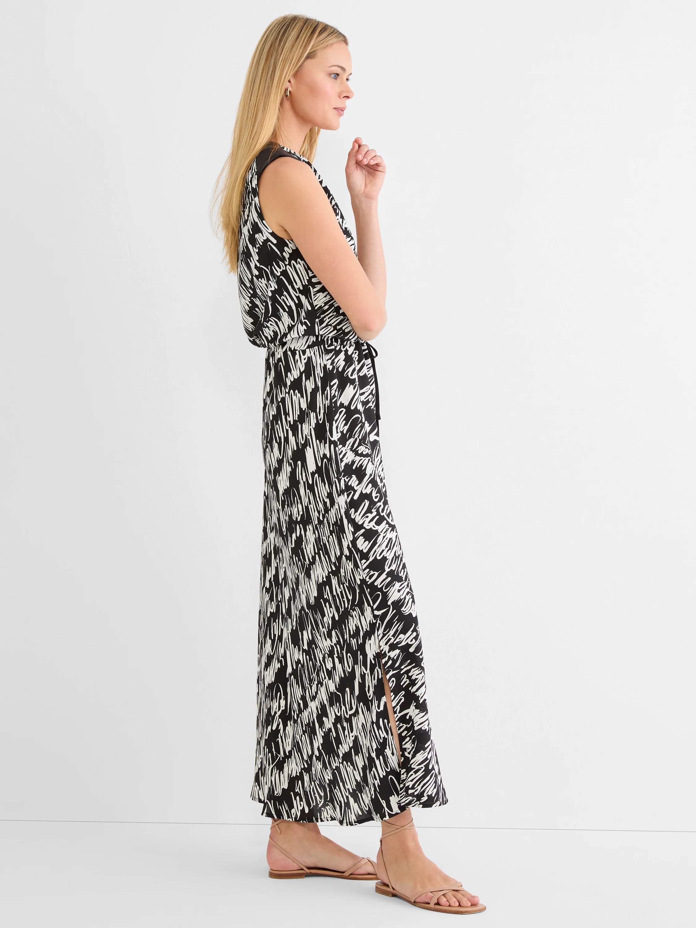 Sleeveless black and white cursive print maxi dress, cinched waist, and side slit.