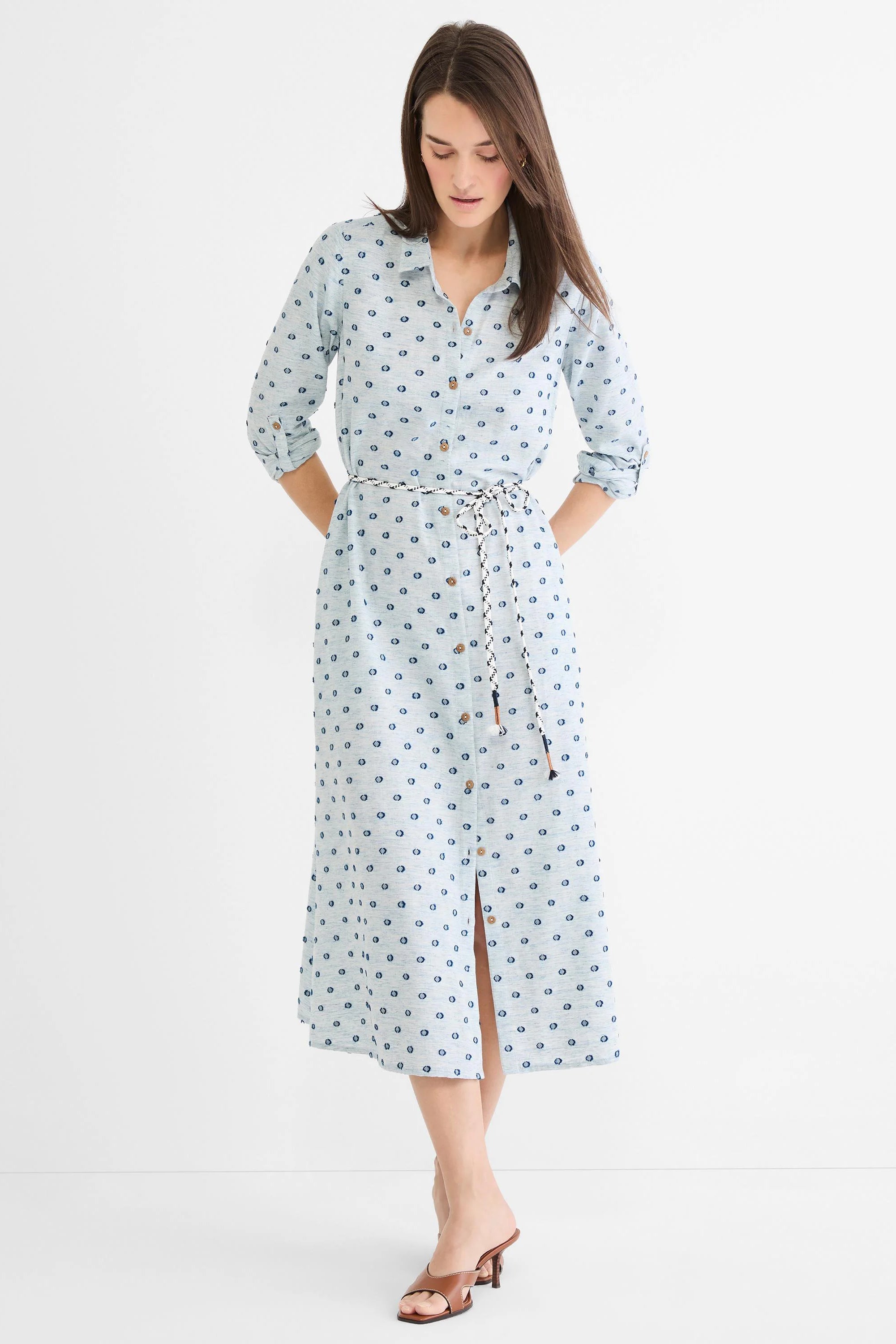 Light blue midi shirt dress with dark blue clipped dots, full button-front, brown buttons, and a braided black/white rope...