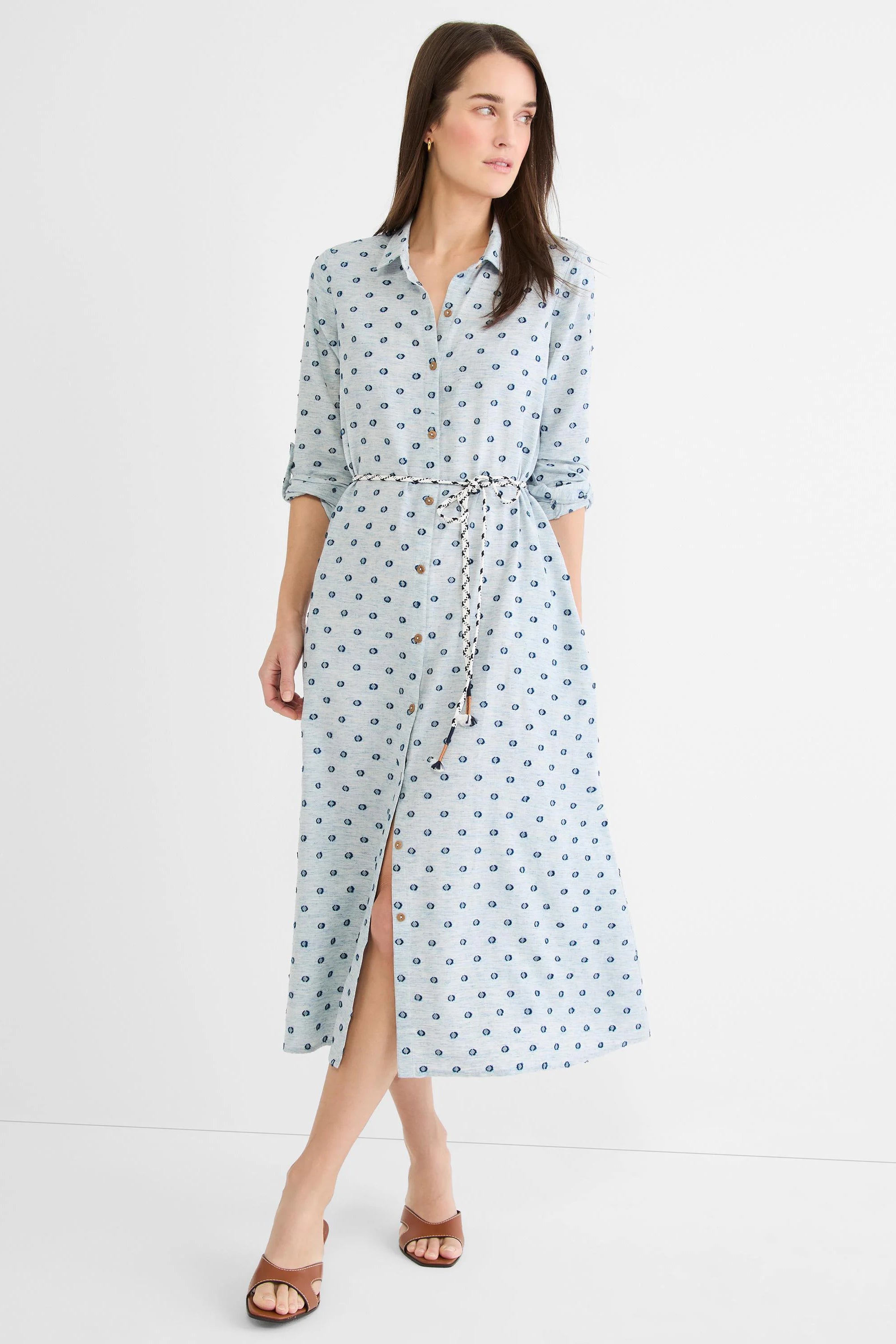 Pale blue midi shirt dress with dark blue clipped dots, button-front, braided belt, rolled sleeves, and front slit.
