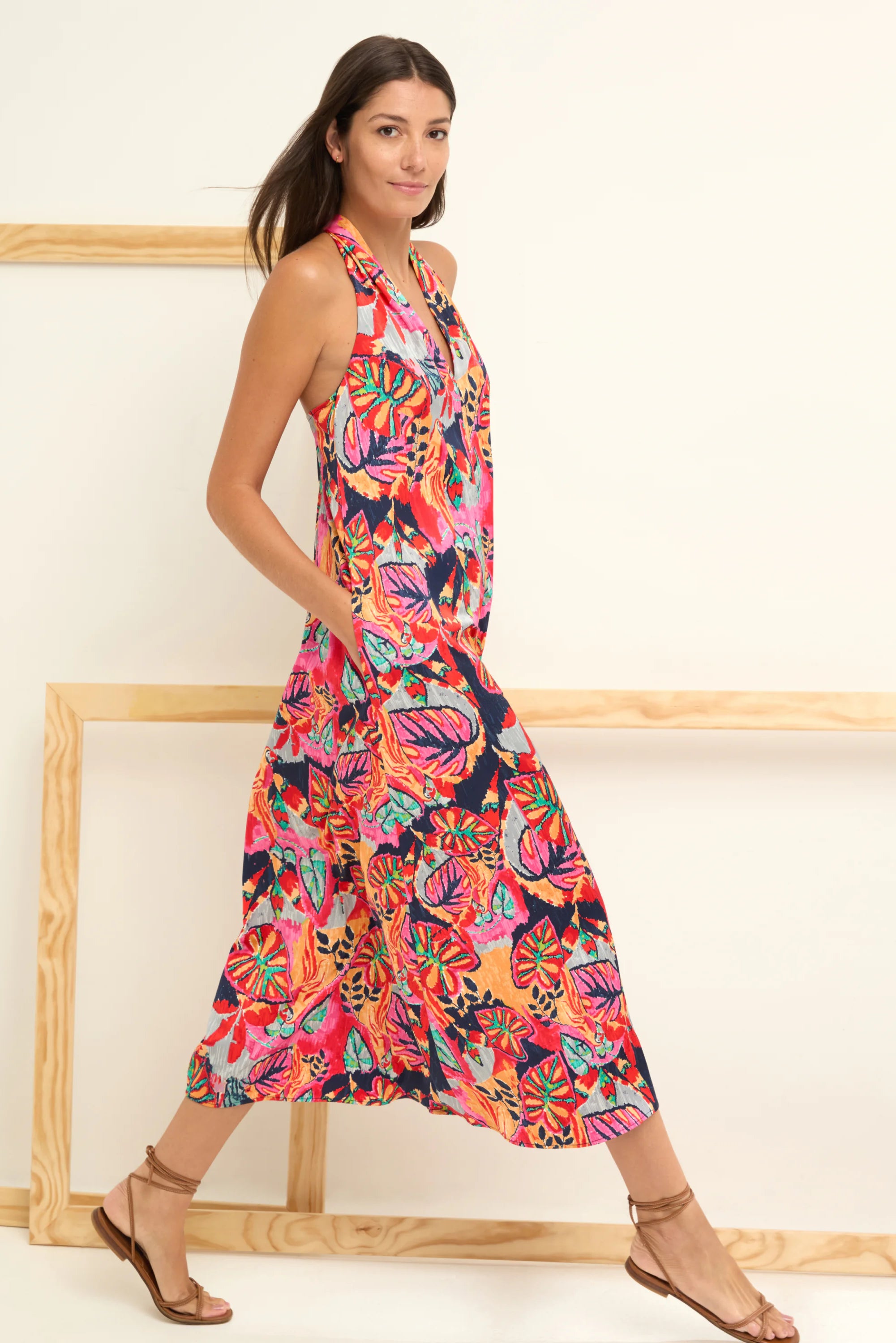 Navy halter midi dress with vibrant pink, red, orange, teal abstract floral print and pockets.
