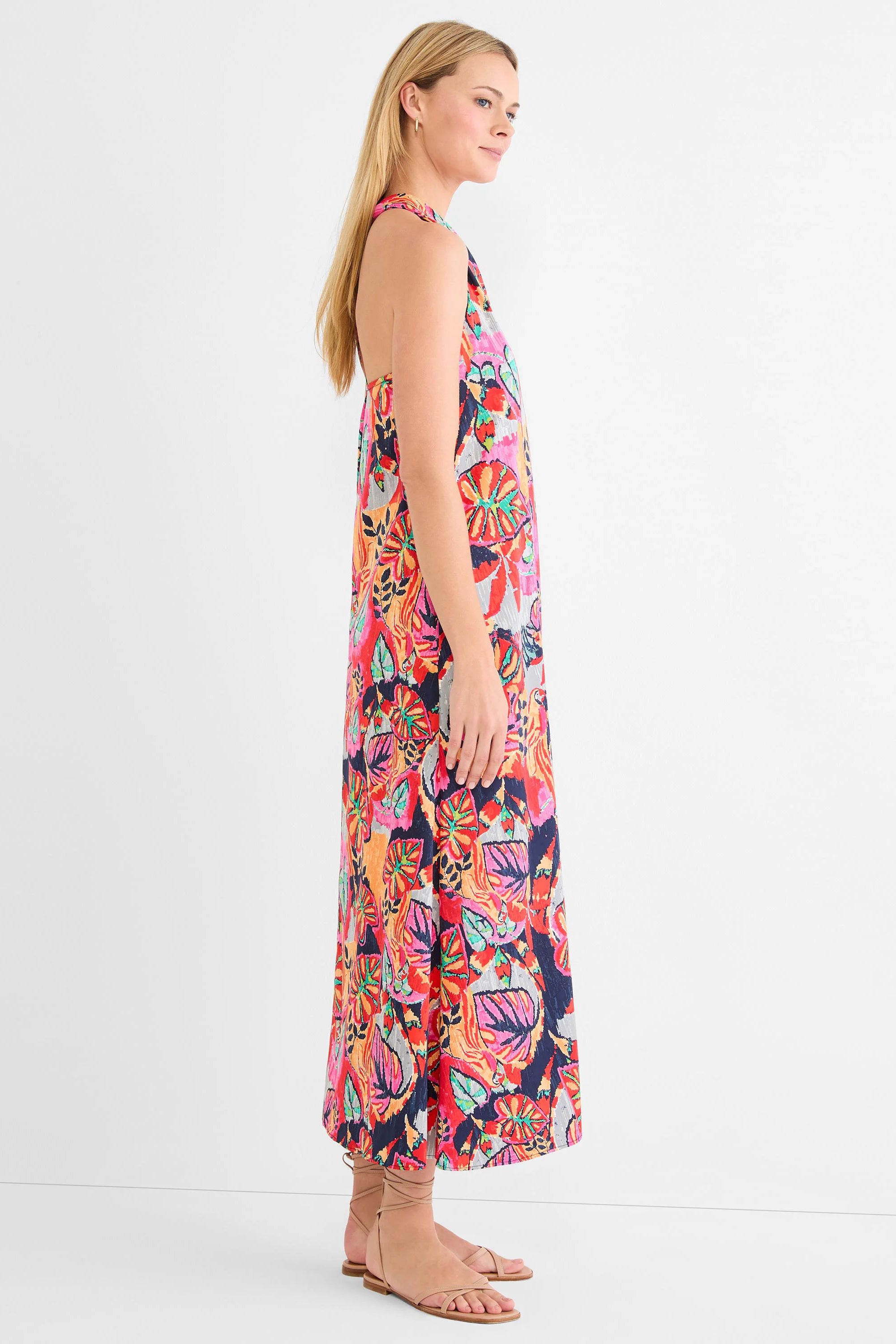 Sleeveless maxi dress with vibrant tropical print in fuchsia, orange, red, navy, and teal colors.