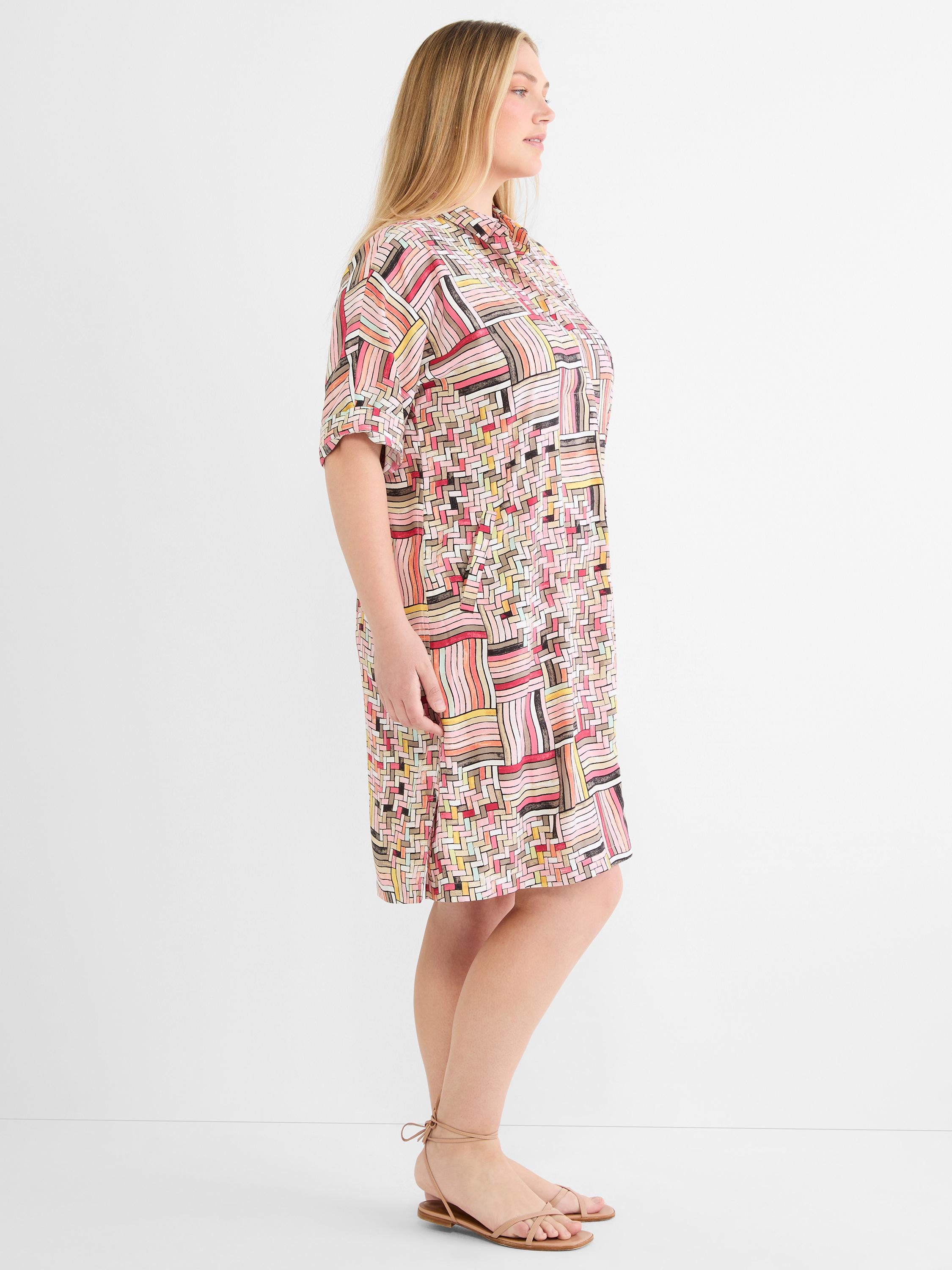 A relaxed multicolor geometric print shirt dress features a collar, cuffed short sleeves, and hits above the knee.