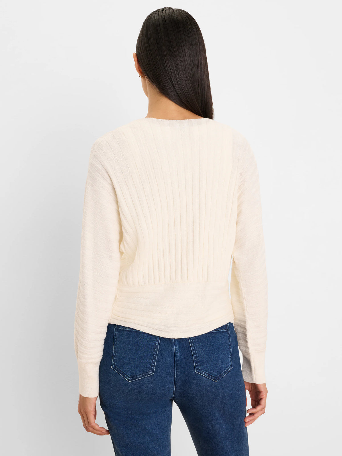 Cream accordion cardigan with deep vertical ribbing and a soft, cinched waist detail, shown from the back.