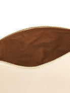 Partially open cream-colored case, revealing gold zipper teeth and a brown fabric interior.