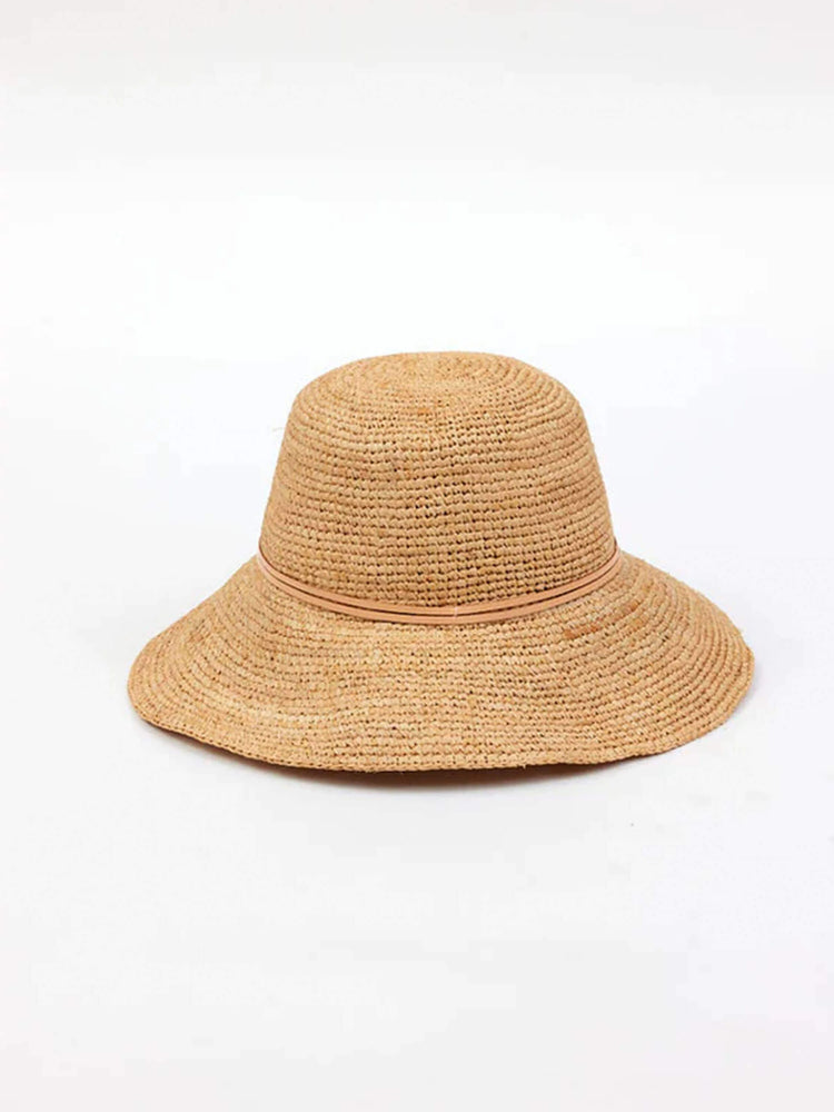 Light brown crochet bucket hat with a wide, slightly wavy brim and a thin lighter band around the crown.