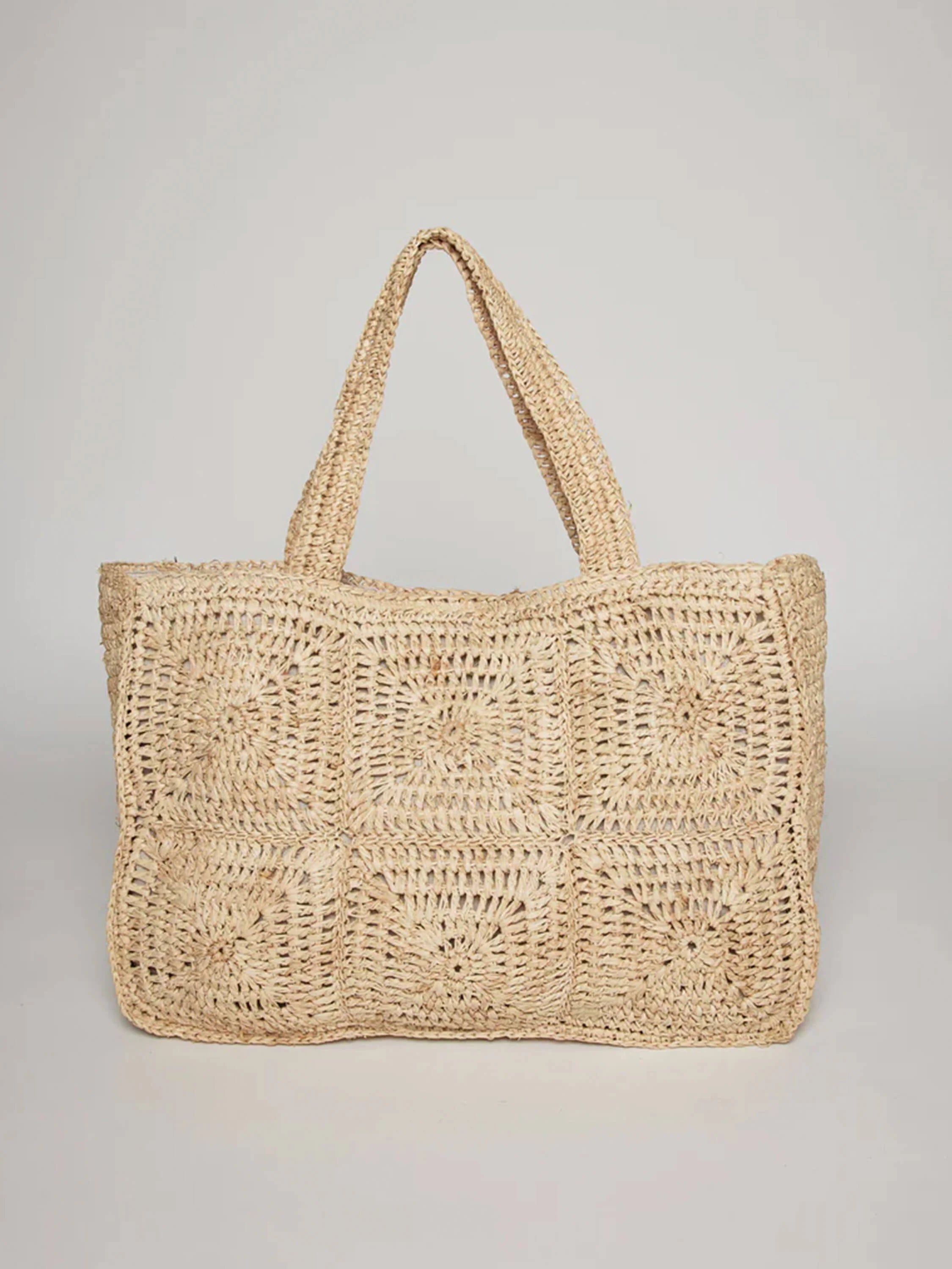 Beige crochet tote bag. Large, square, circular patterns. Two top handles.