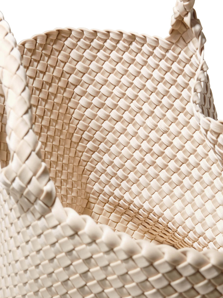 Off-white woven tote bag. Close-up shows intricate, grid-like pattern. Braided handles.