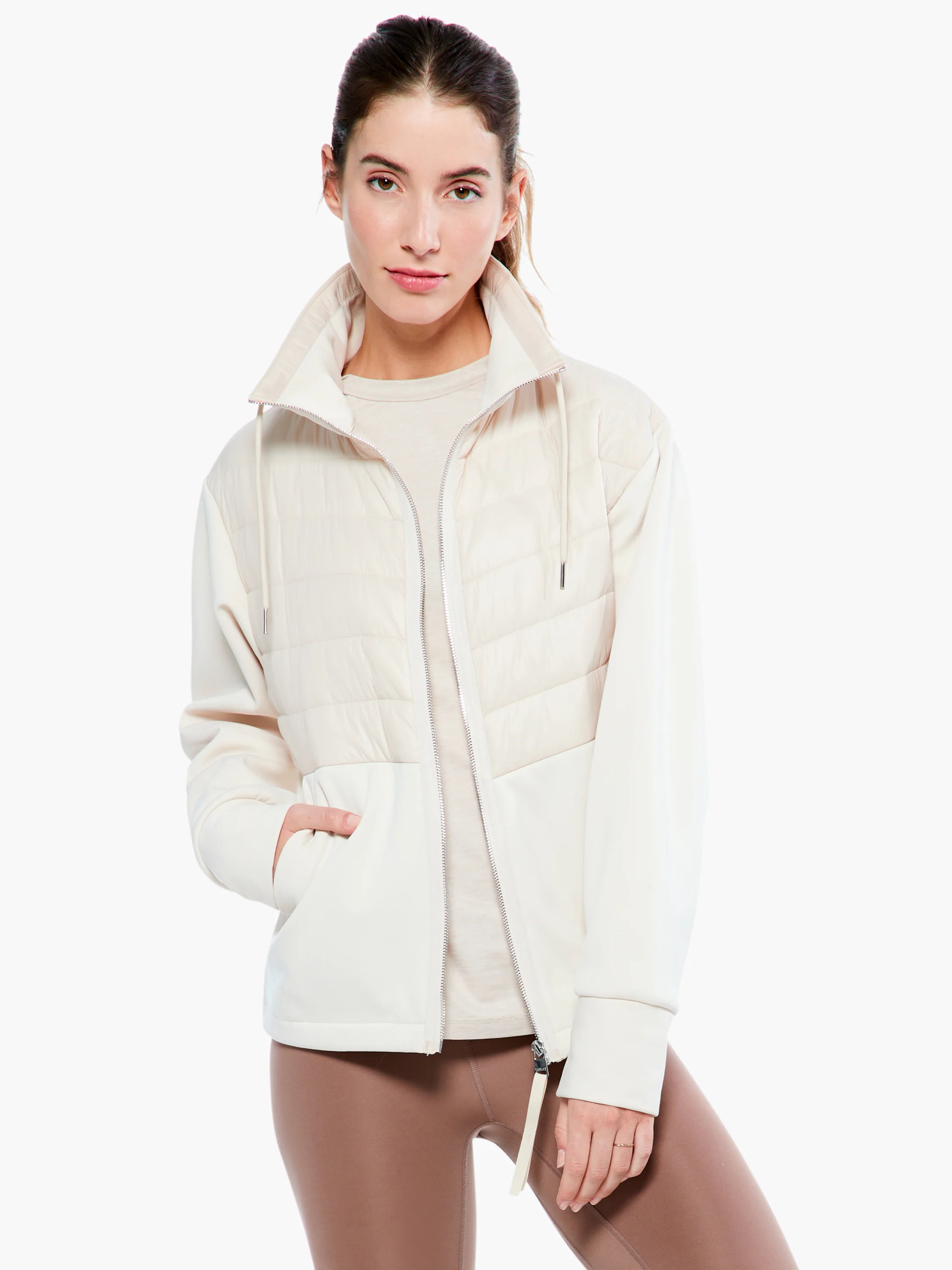 Cream jacket with quilted chest, smooth sleeves & lower body, high collar, and silver full-zip front.