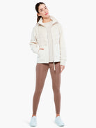 Cream Varley Belfern jacket with a padded front, smooth sleeves, high collar, and full zipper.