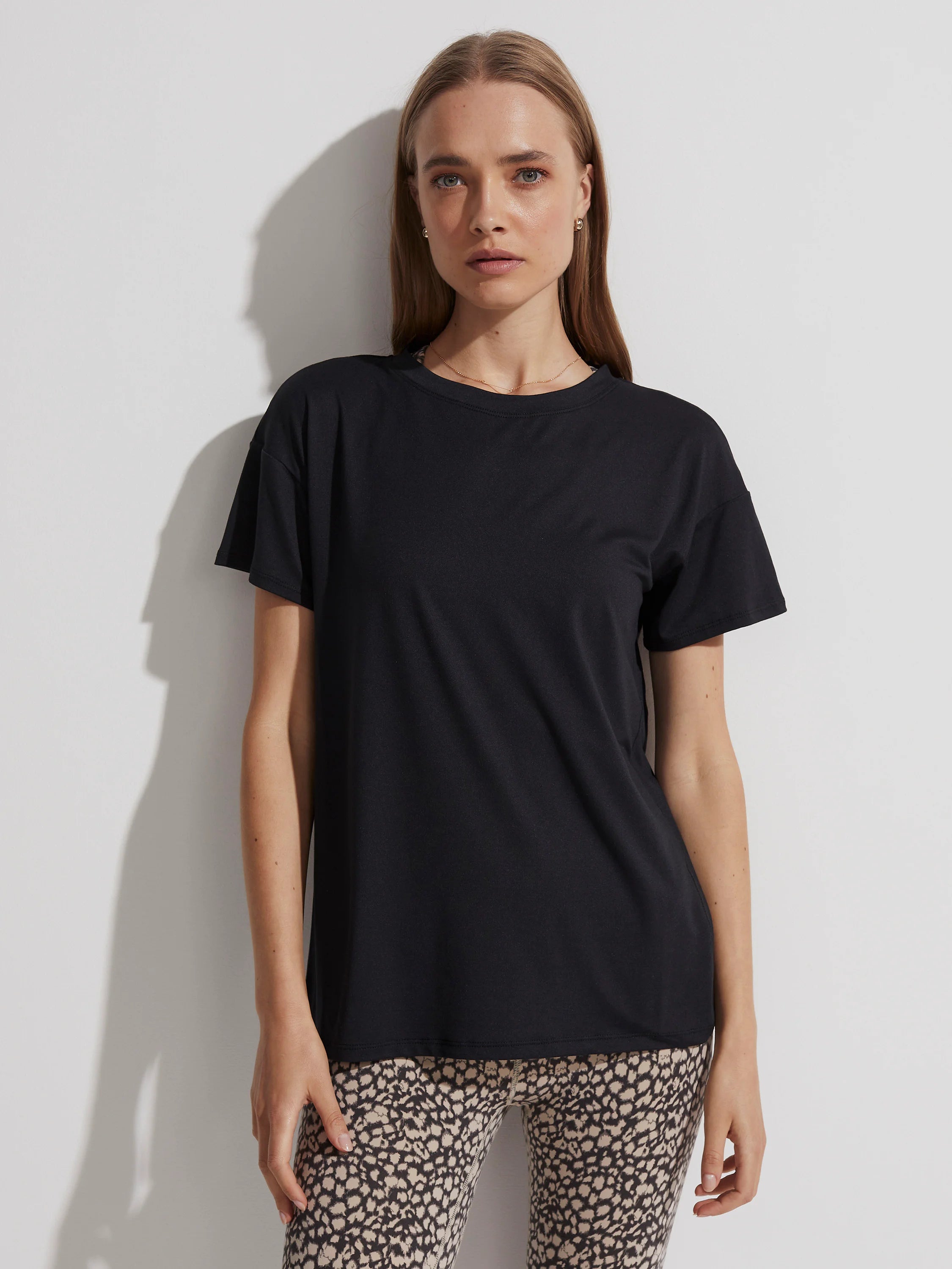 Black crew neck t-shirt with short sleeves and a relaxed fit.