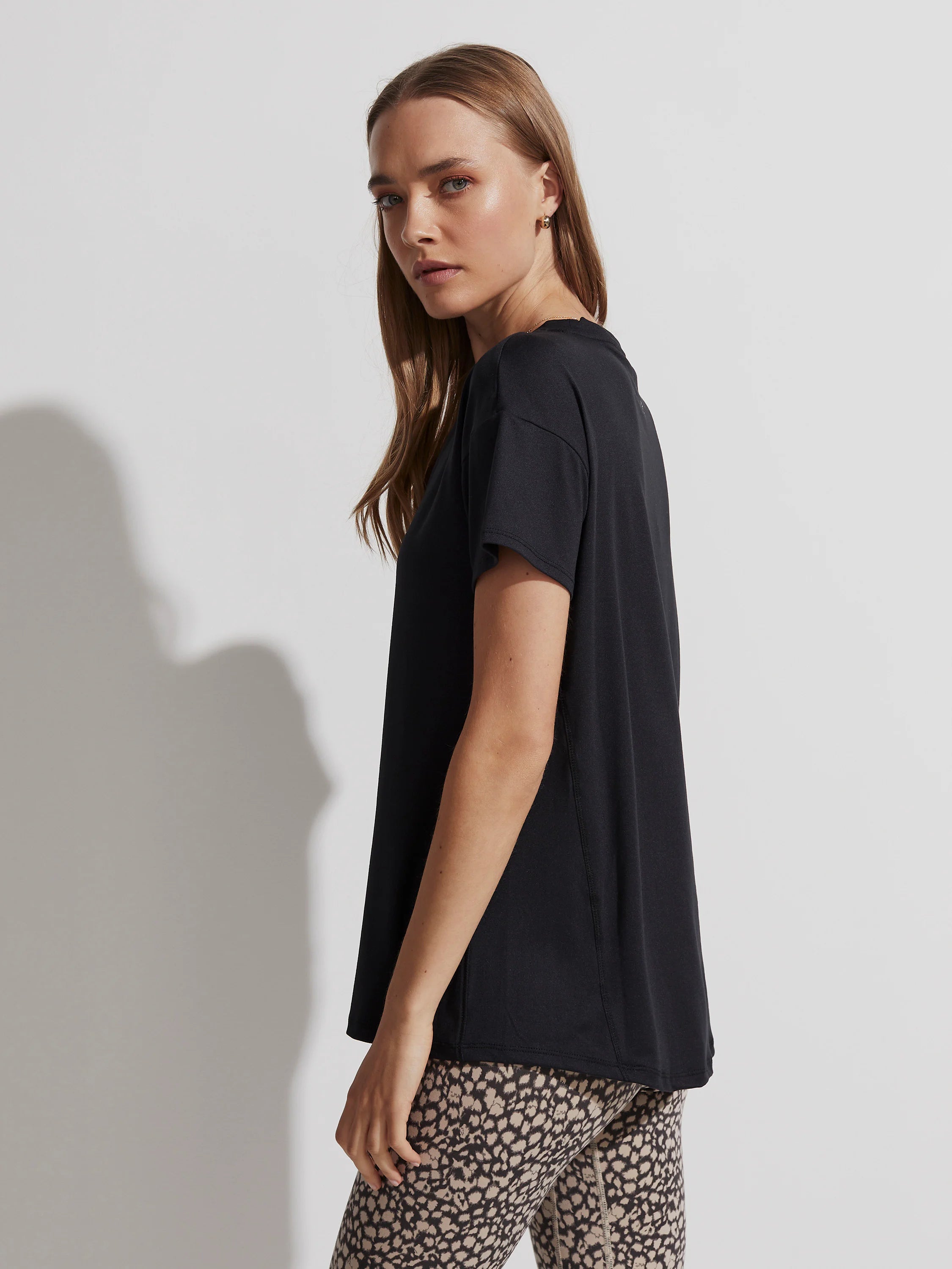 Black, loose-fit t-shirt with short sleeves and a subtly longer back hem.