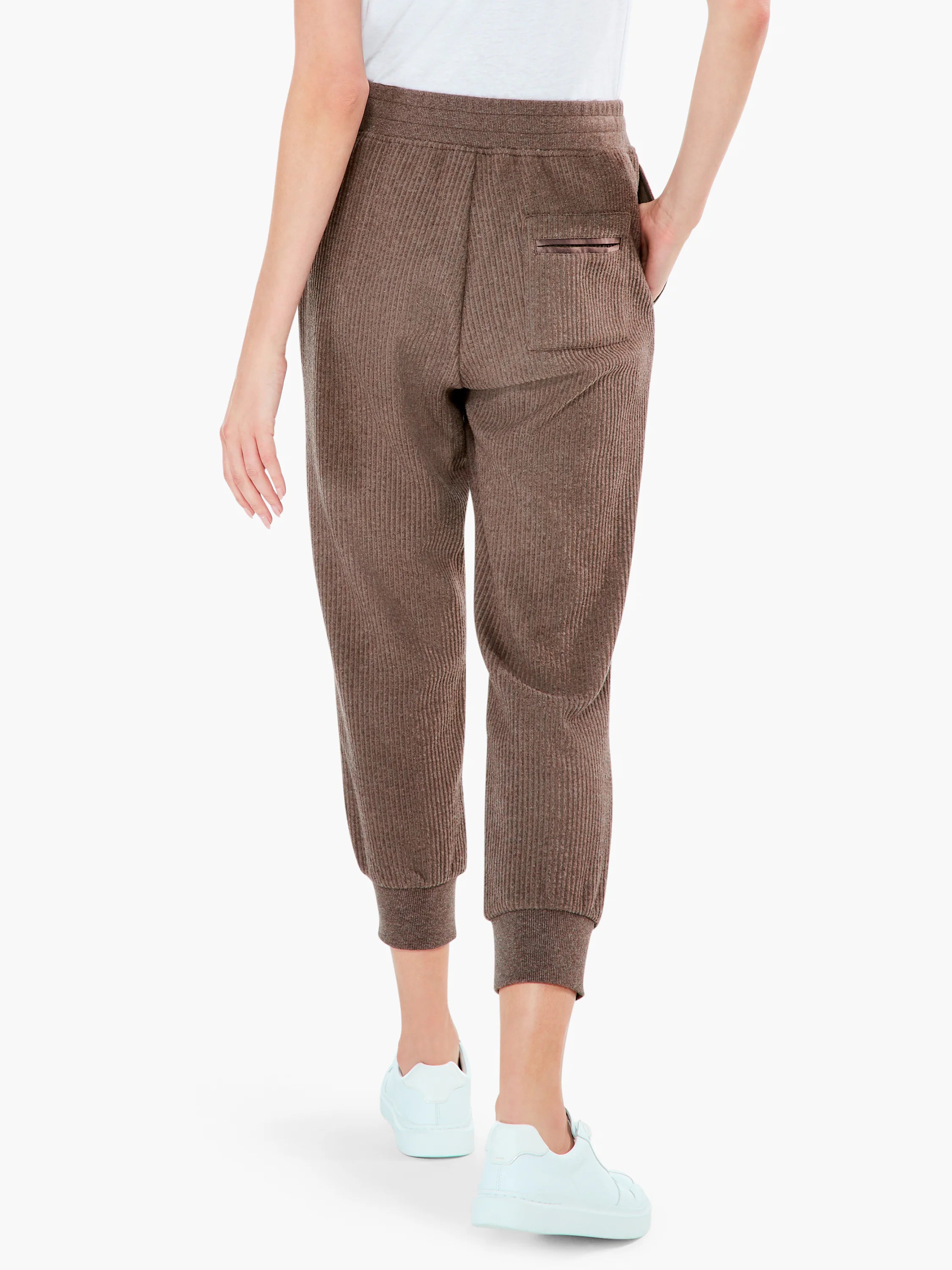 Brown ribbed sweatpants with elasticated waist, ribbed cuffs, and back slit pocket with dark trim, shown from behind.