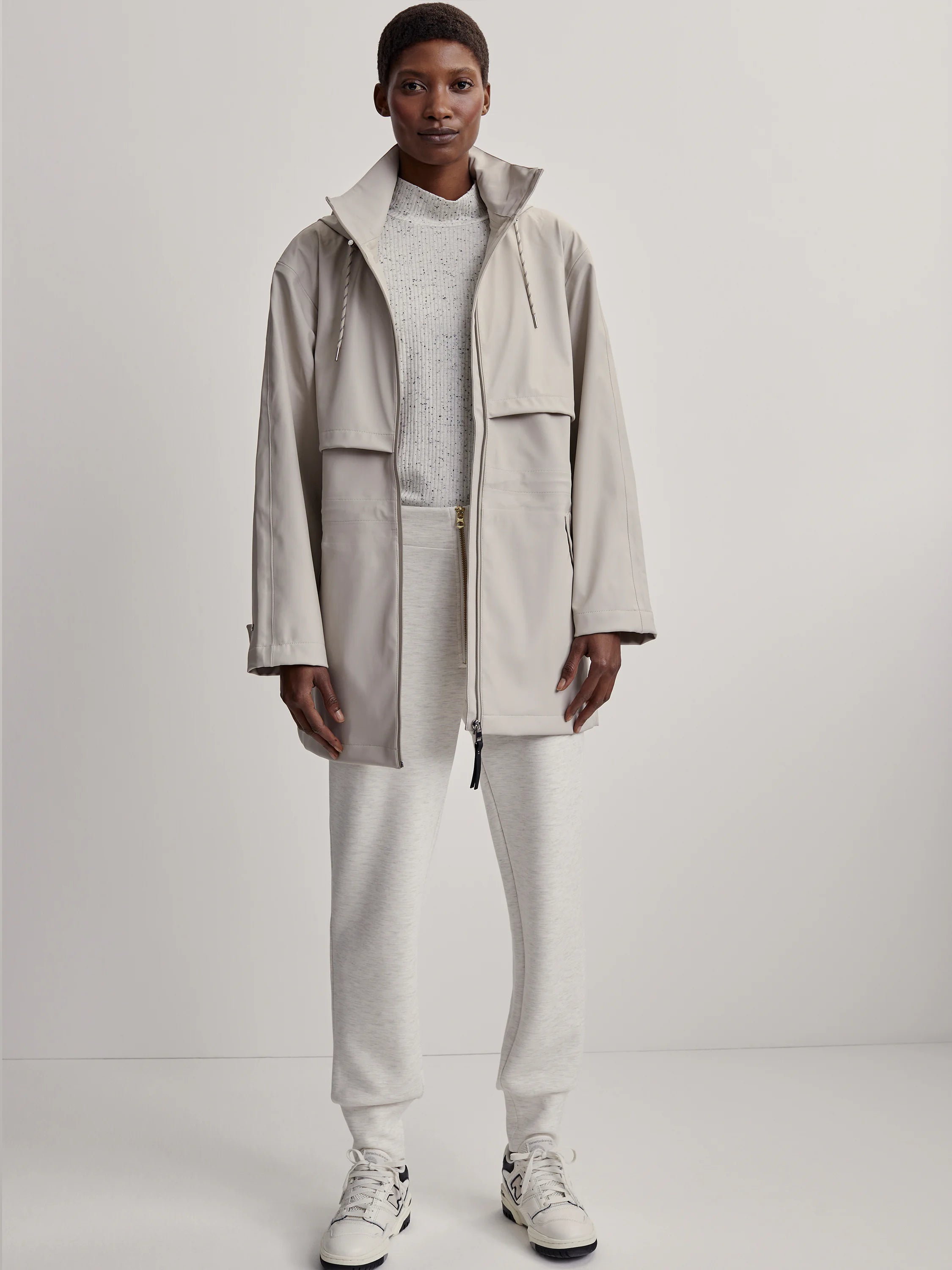 Light beige raincoat; long sleeves, zip front, and hood.