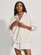 Off-white half-zip sweatshirt with a slightly relaxed fit and gold zipper.  Features a small logo tag.