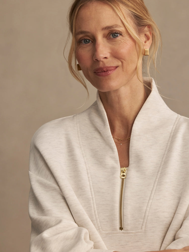 Pale beige marl sweatshirt with a high collar and gold front zipper.