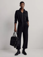 Black Varley Kelso Crossbody Bag. Tote style with top handles, a light grey-backed strap, and silver zip pockets.