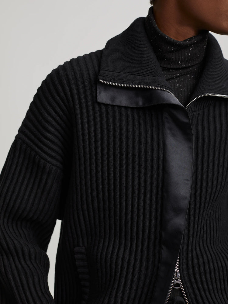 Black heavy rib knit mock neck sweater with silver front zipper and smooth black panel detail.