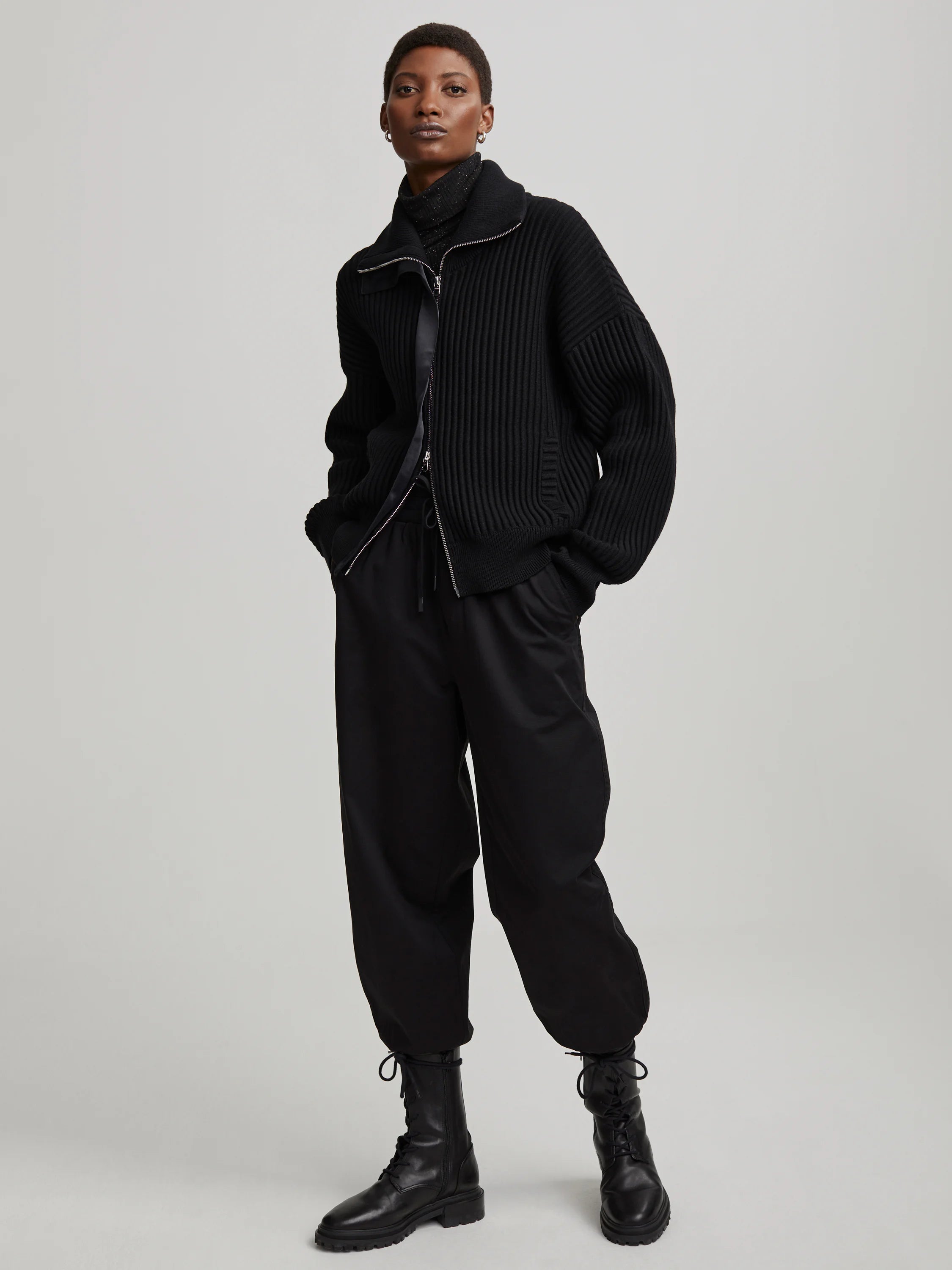 Black ribbed mock neck knit sweater with silver full zip-front.