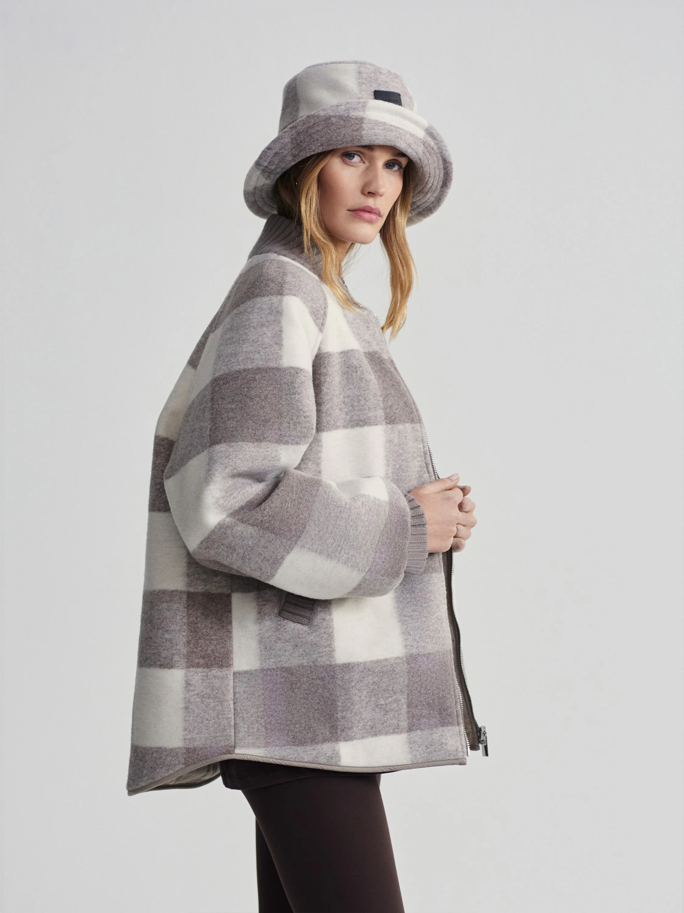 Light grey and taupe large checkerboard jacket with ribbed collar, cuffs, and front zip closure.