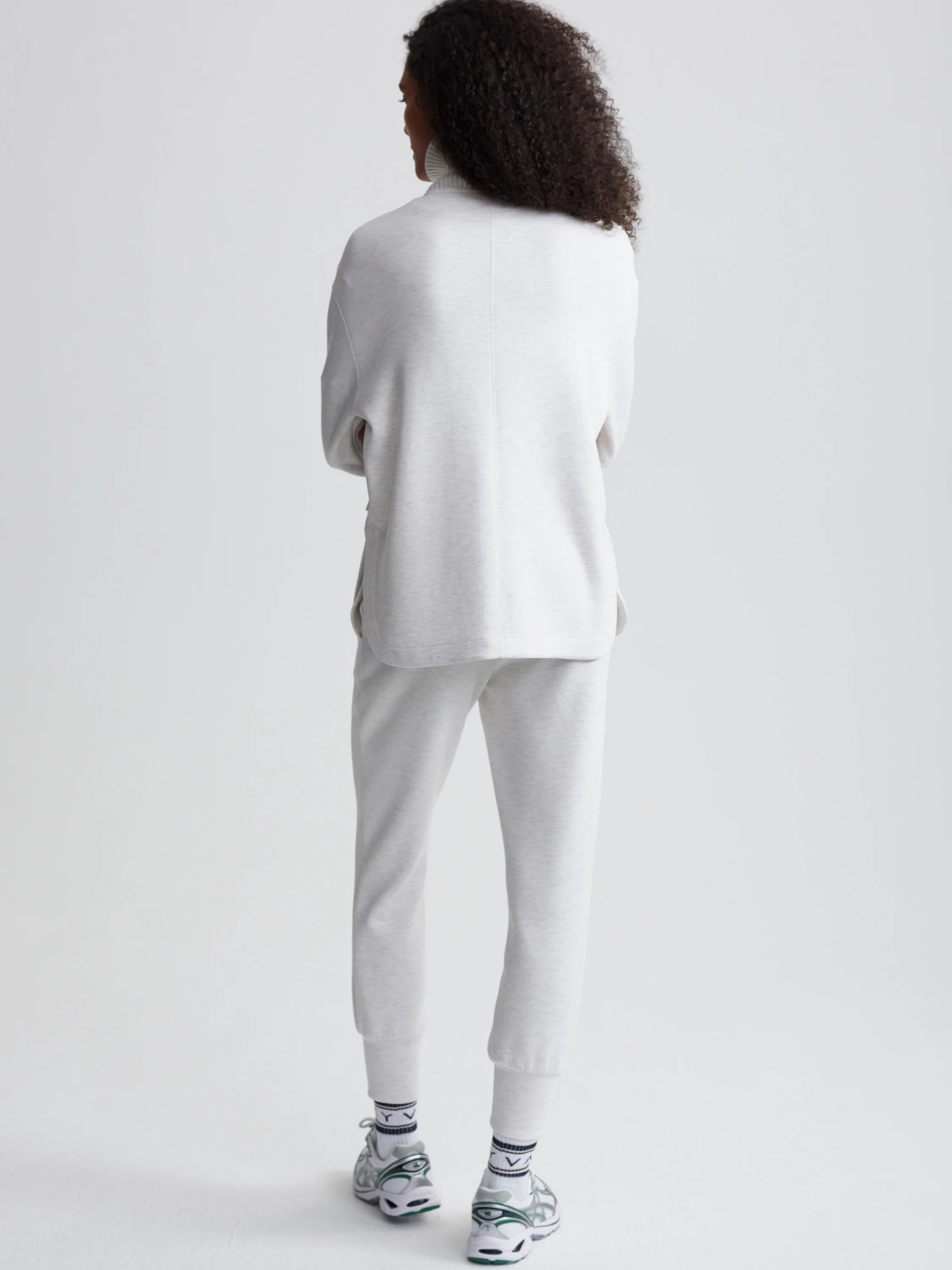 Light gray zip-through jacket, shown from the back. The model also wears matching light gray joggers.