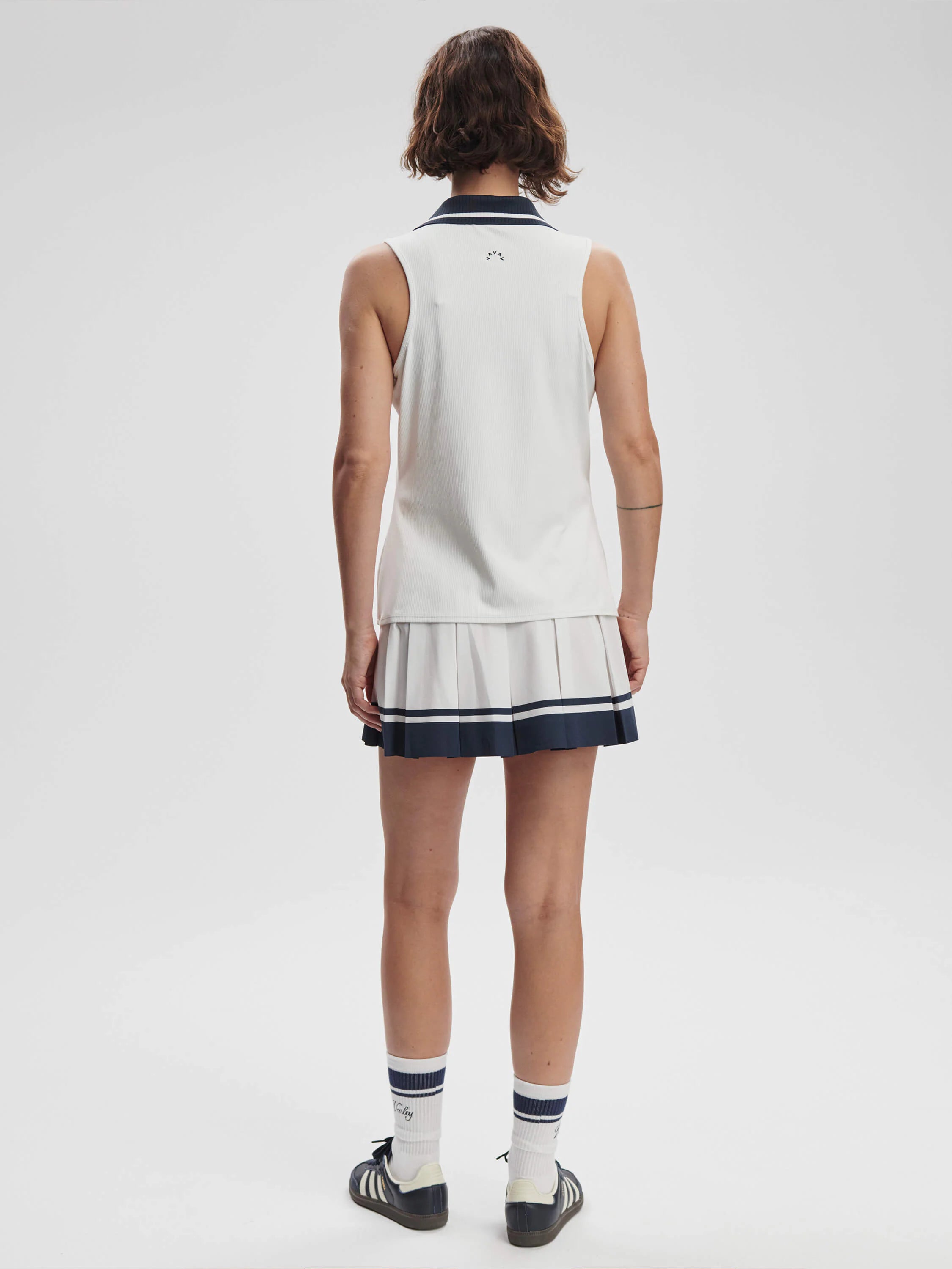 Here's alt text for the image, under 125 characters:
White ribbed sleeveless top with navy trim, paired with a white...