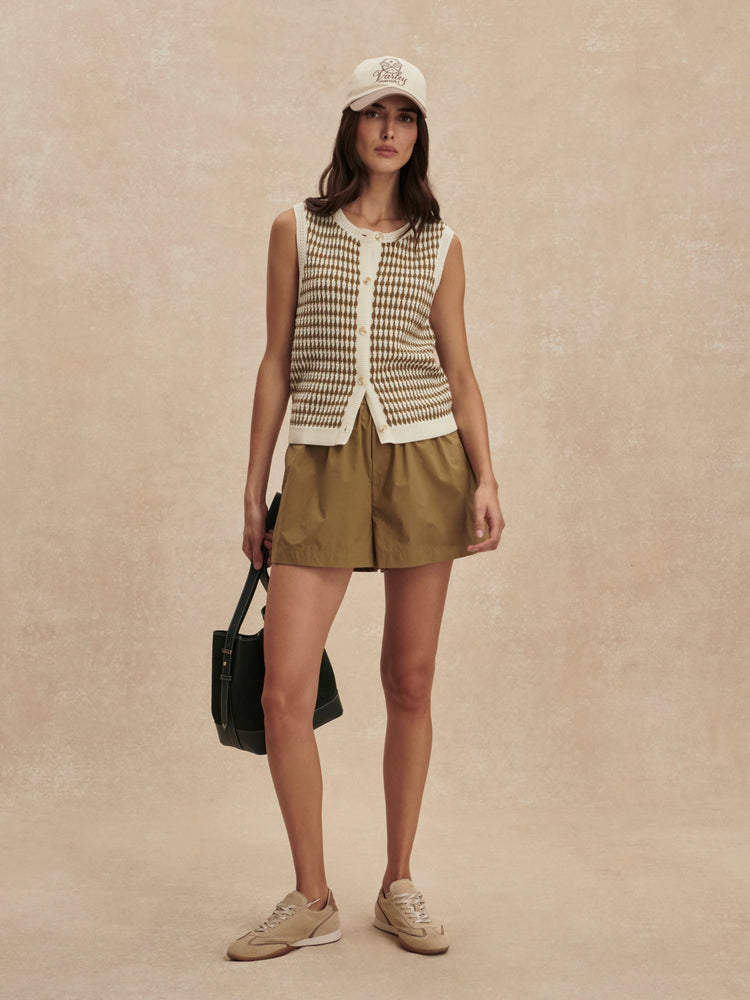 Sleeveless knit top featuring a cream and brown small checkerboard pattern and front buttons.