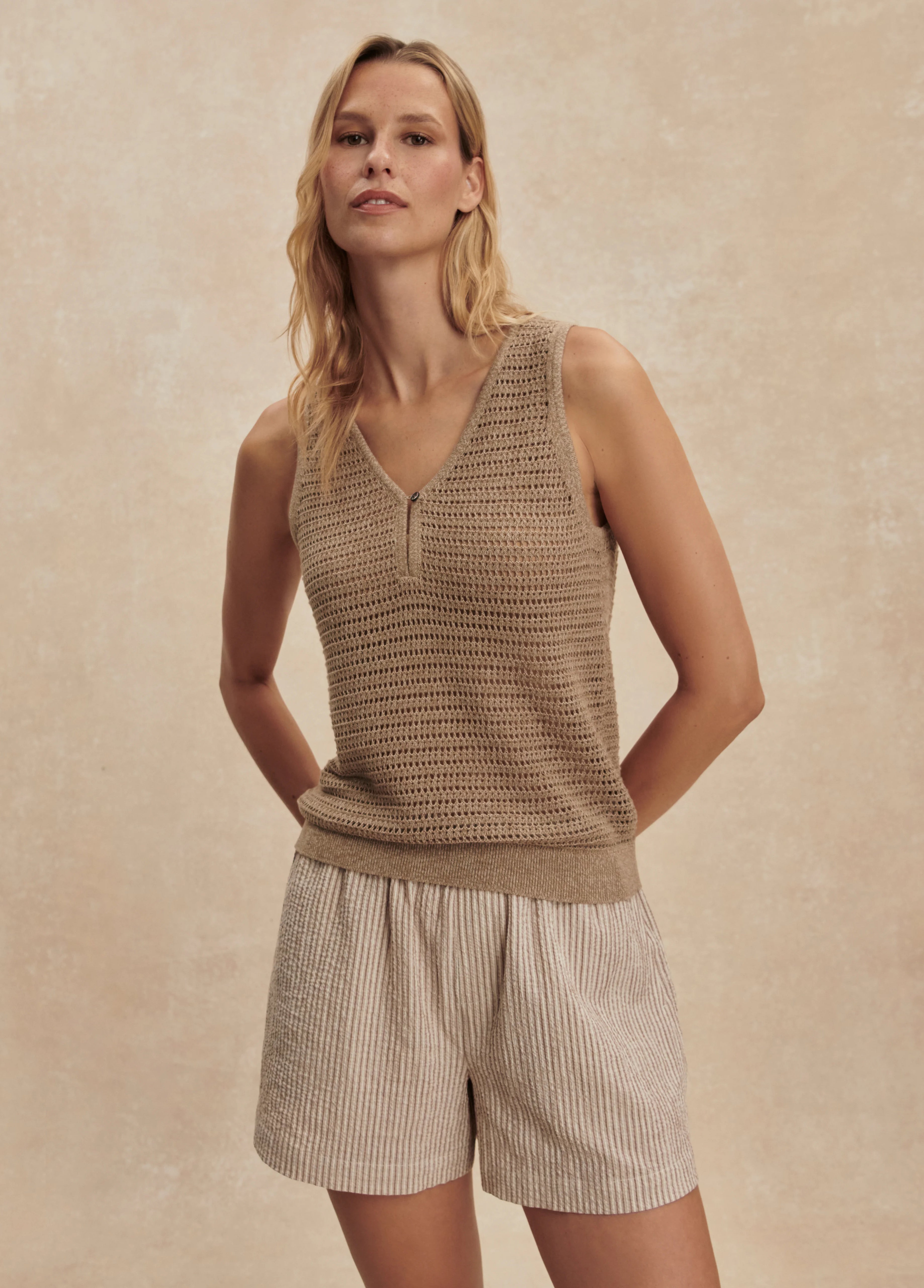 Tan open-knit V-neck tank with a single button henley placket.