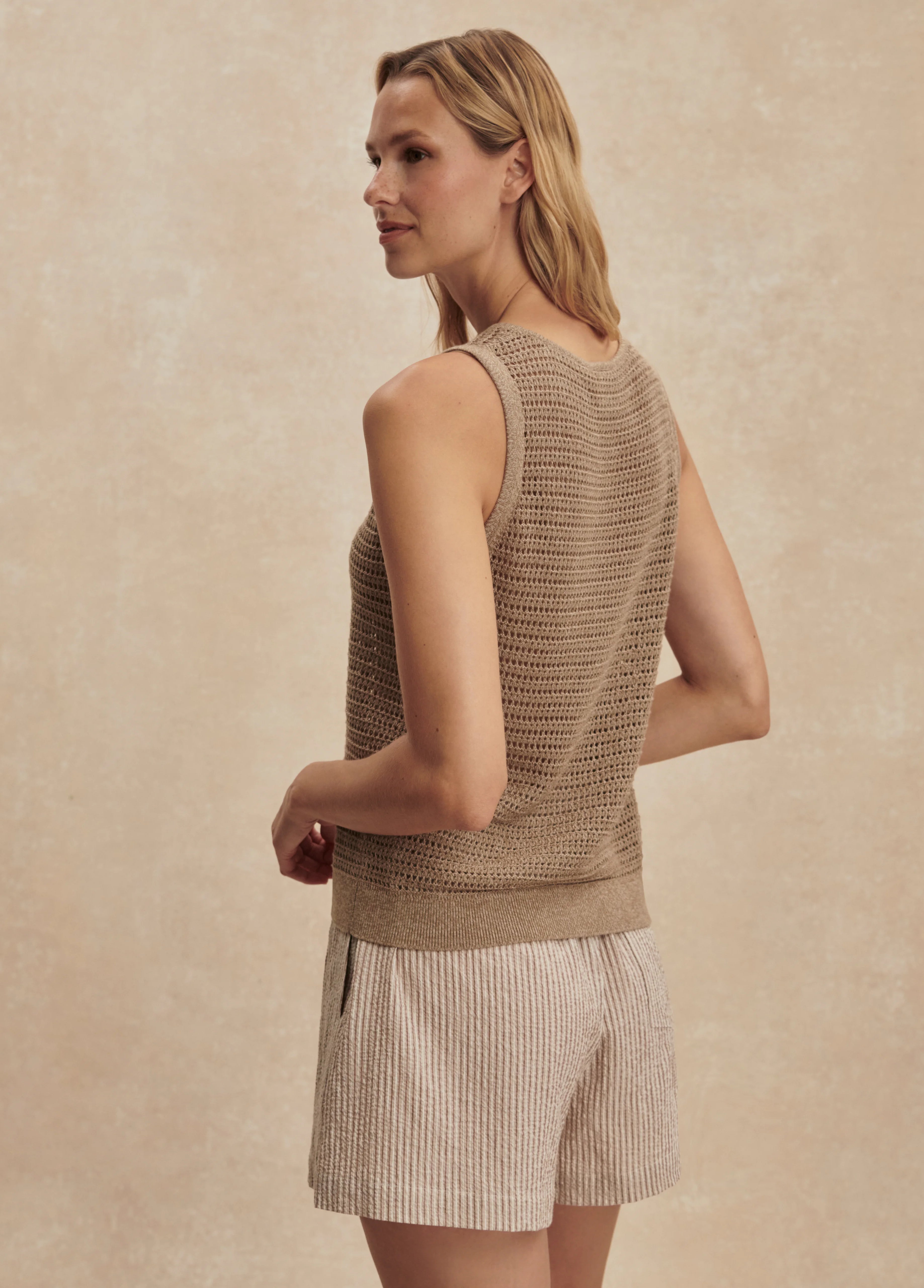 Tan open-knit tank top, sleeveless, with a ribbed hem.