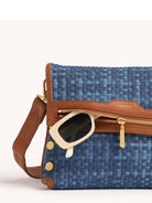 Blue woven denim bag with brown leather trim, gold hardware, and white sunglasses partially out of top zipper.