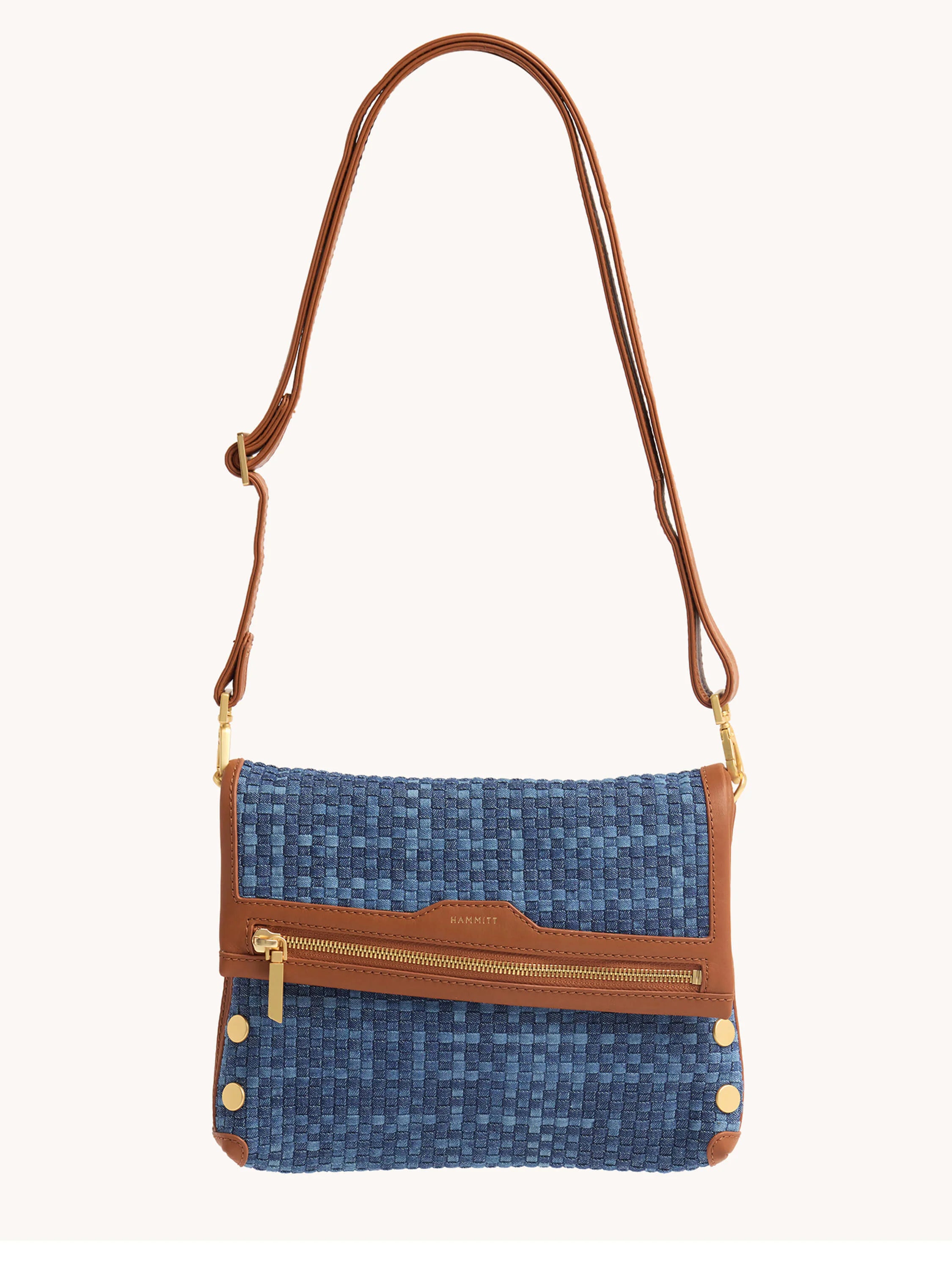 Blue woven bag with brown leather trim and adjustable strap. Features a gold zipper and decorative studs.