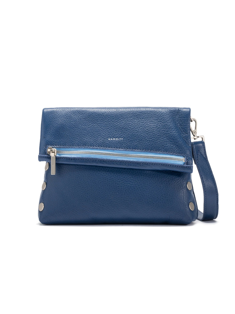 Navy pebbled leather bag with fold-over flap, silver zipper, studs, and a light blue accent.