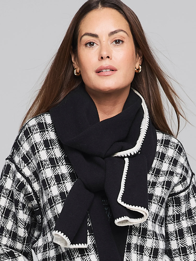 Black scarf with off-white scalloped edges.