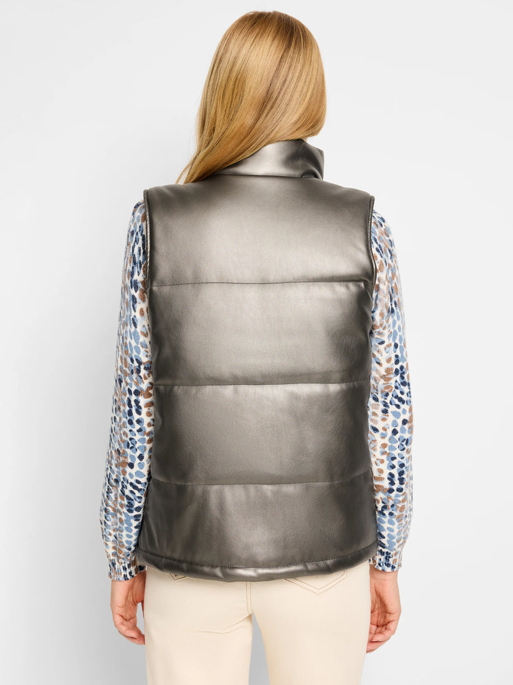 Gunmetal gray puffer vest. Three horizontal seams. Faux leather. Shown with a patterned top.