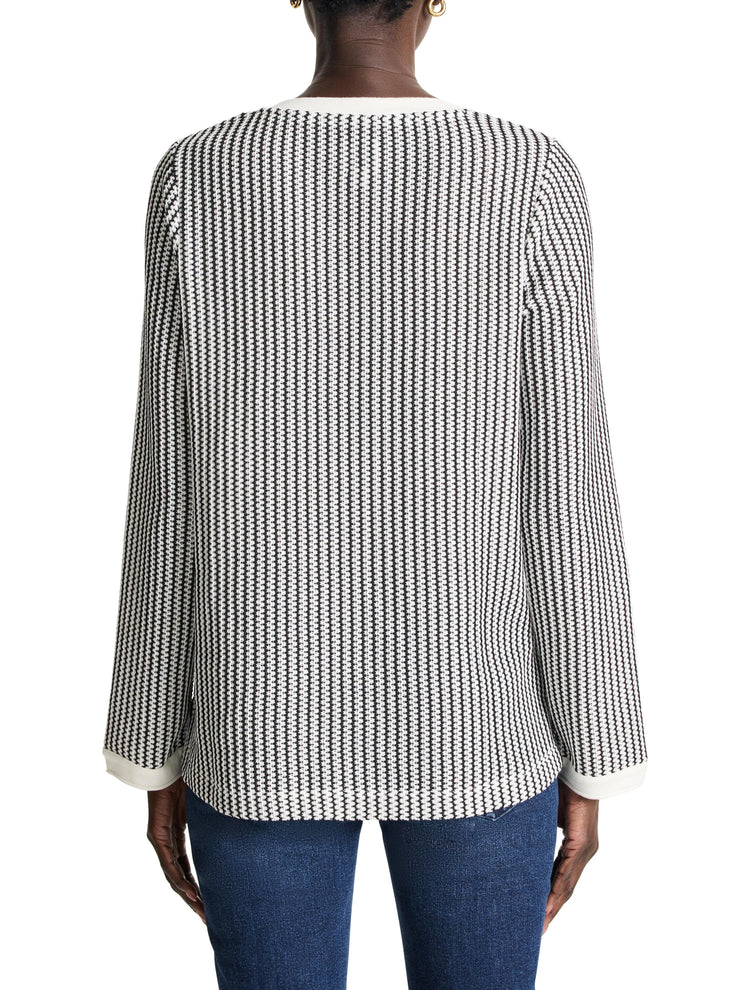 Black and white vertically striped knit top with split neck and cream-colored trim at neckline and cuffs. Long sleeves.