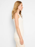 Cream ribbed knit tank top with a scoop neck, shown on a model.