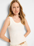 Ivory ribbed knit scoop tank top with vertical ribbing, shown on a model.