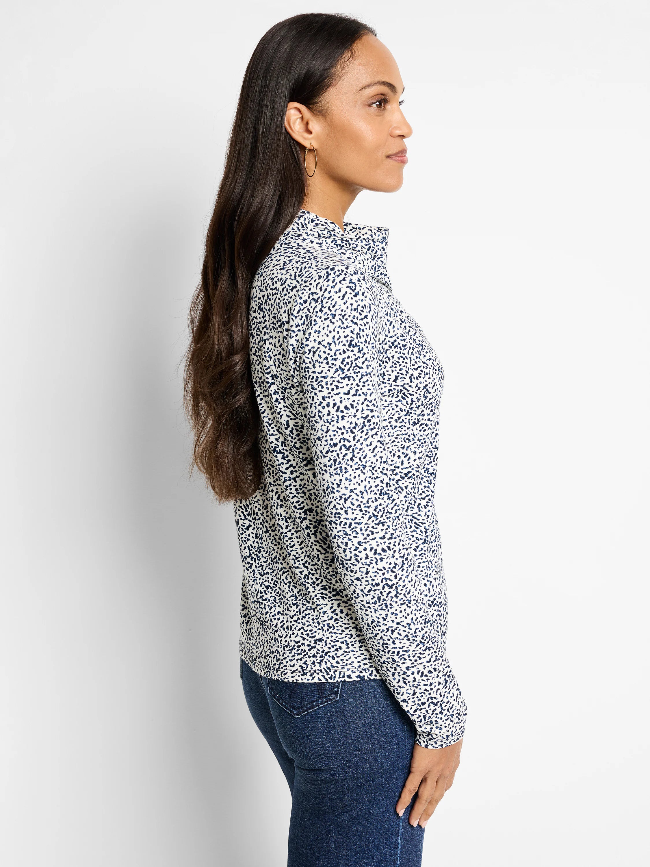 Off-white top with navy blue speckled pattern, long sleeves, and a draped neckline.