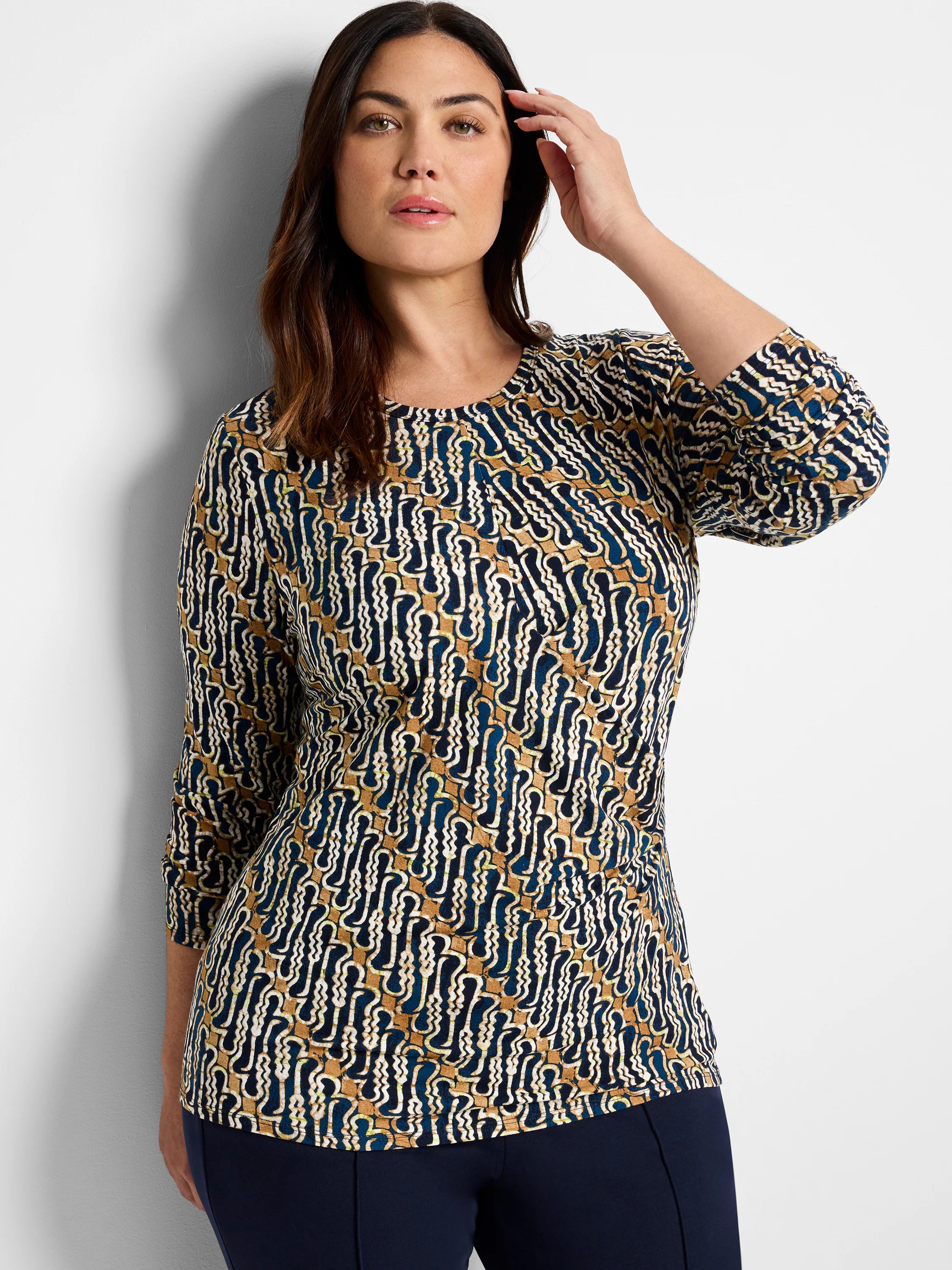 Brown, teal, and cream batik print 3/4 sleeve drape top. Abstract wavy pattern.