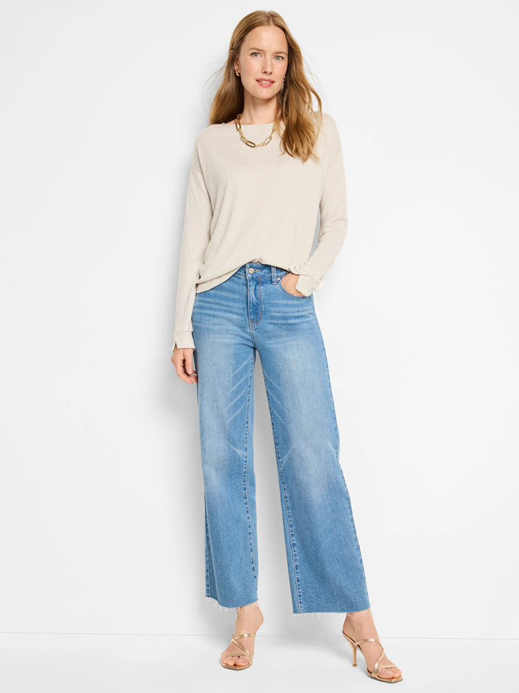 Beige sparkly long-sleeve top. Model also wears light wash jeans and gold heels.