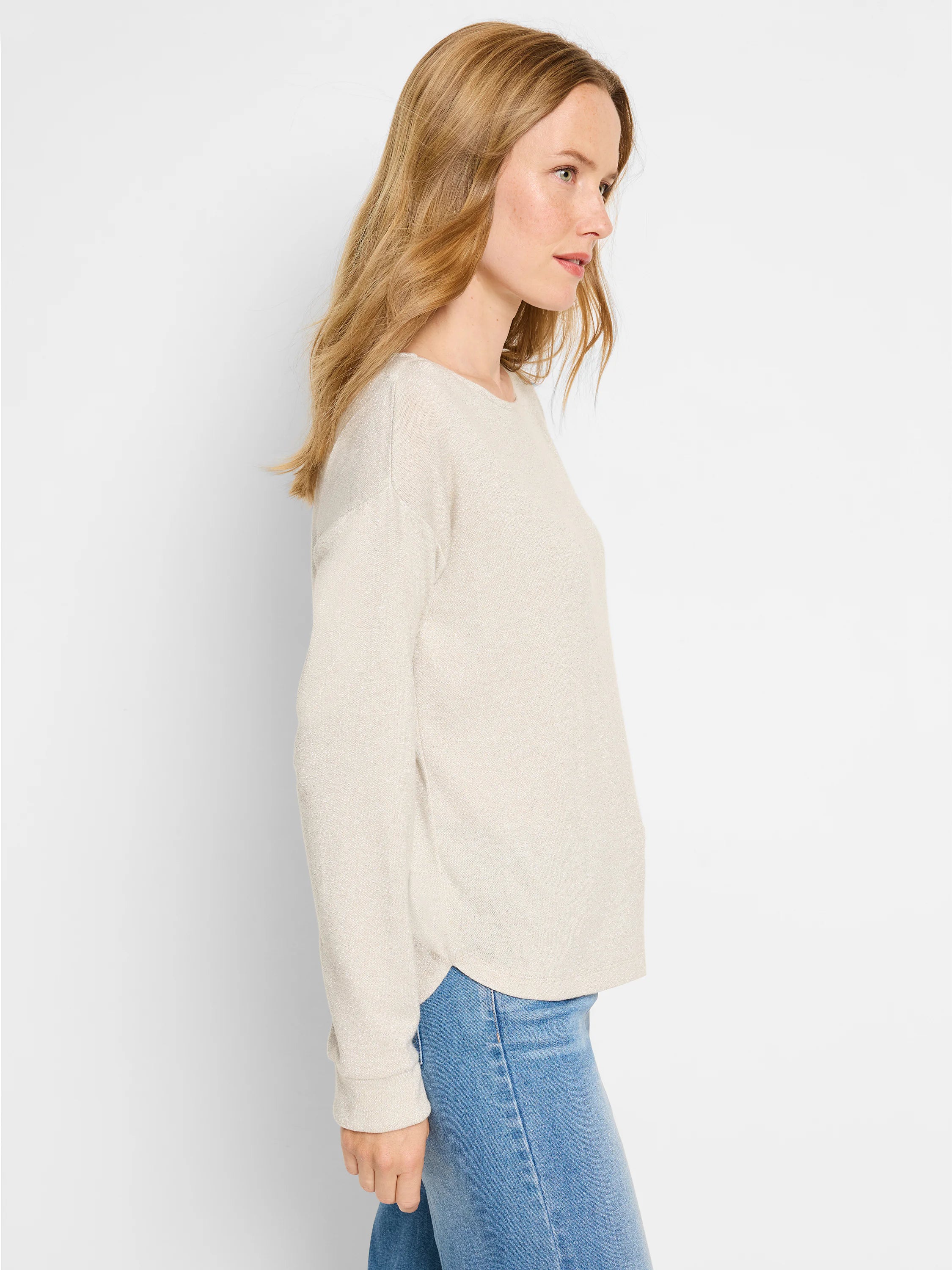 Beige long-sleeve top with subtle sparkle, shown on model.  Slightly curved hem.