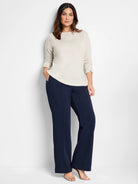 Off-white sparkly top, shown with dark navy blue pants.