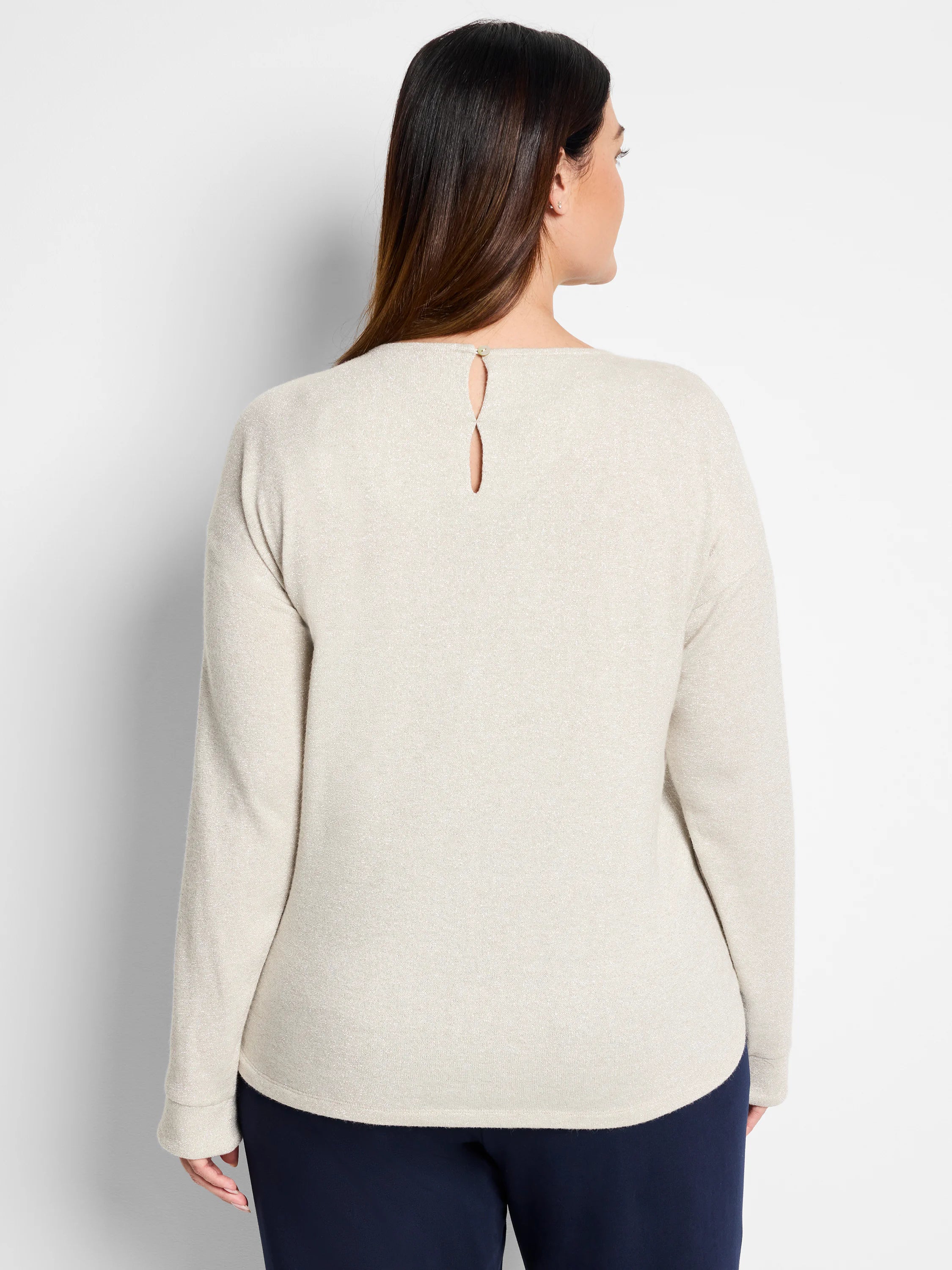 Beige long-sleeved top with subtle sparkle, keyhole back detail, and small gold button.