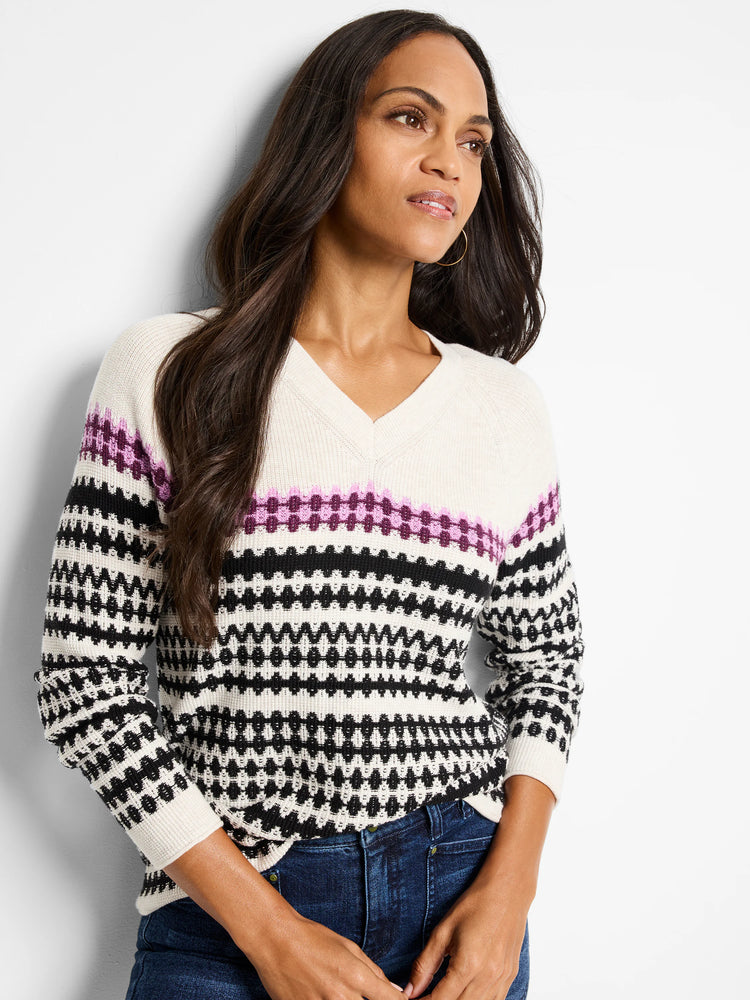 Cream V-neck sweater with black, purple, and white geometric pattern.