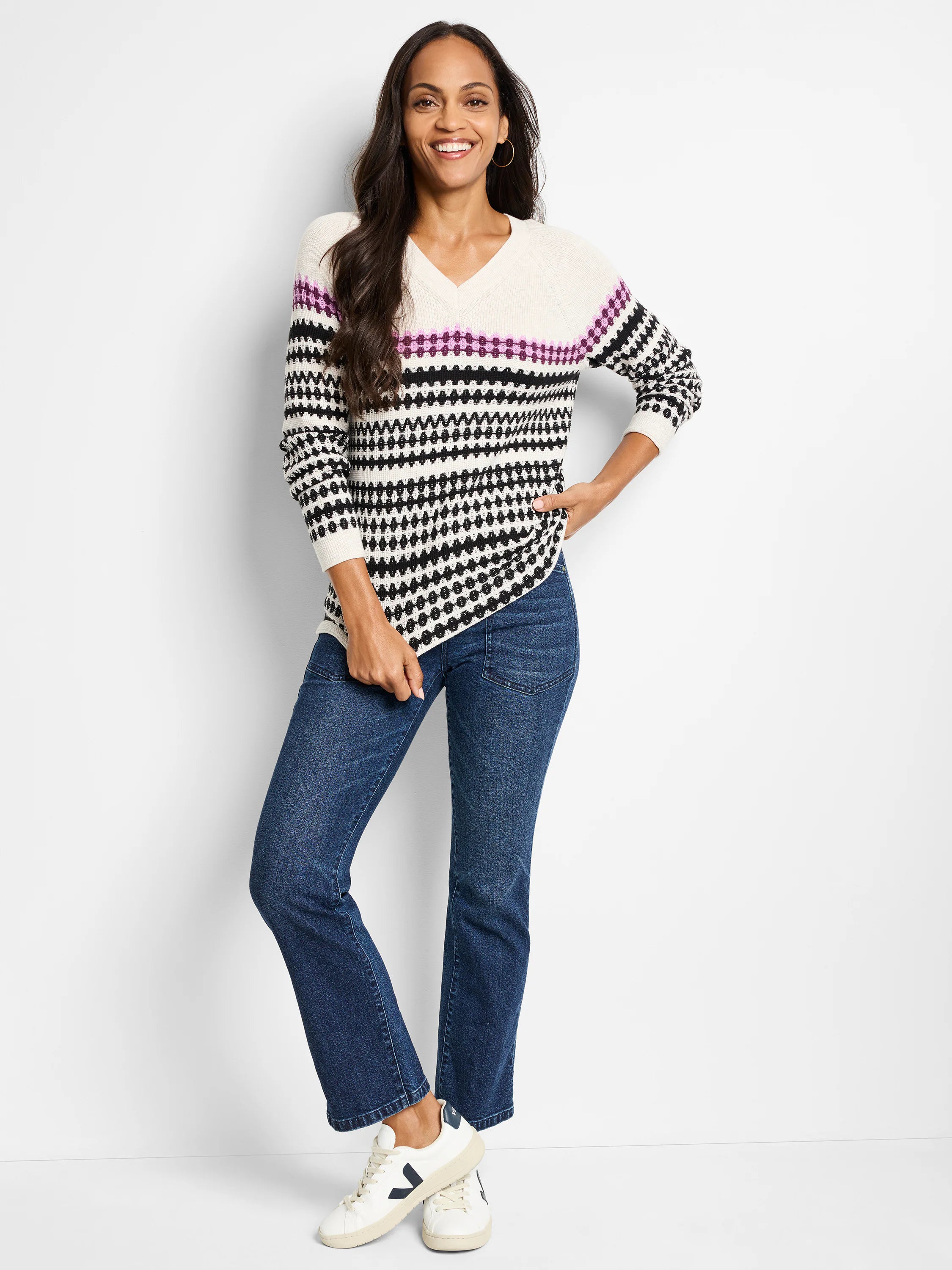 Off-white V-neck sweater with black and purple horizontal stripes and geometric pattern. Long sleeves.
