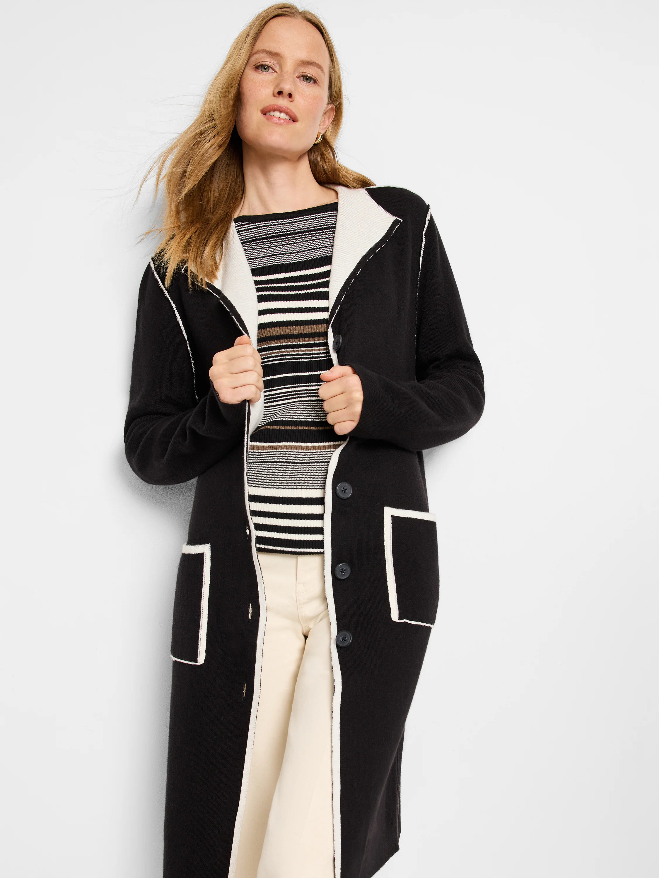 Black reversible jacket with cream trim on lapels, front, and patch pockets. Features dark buttons.