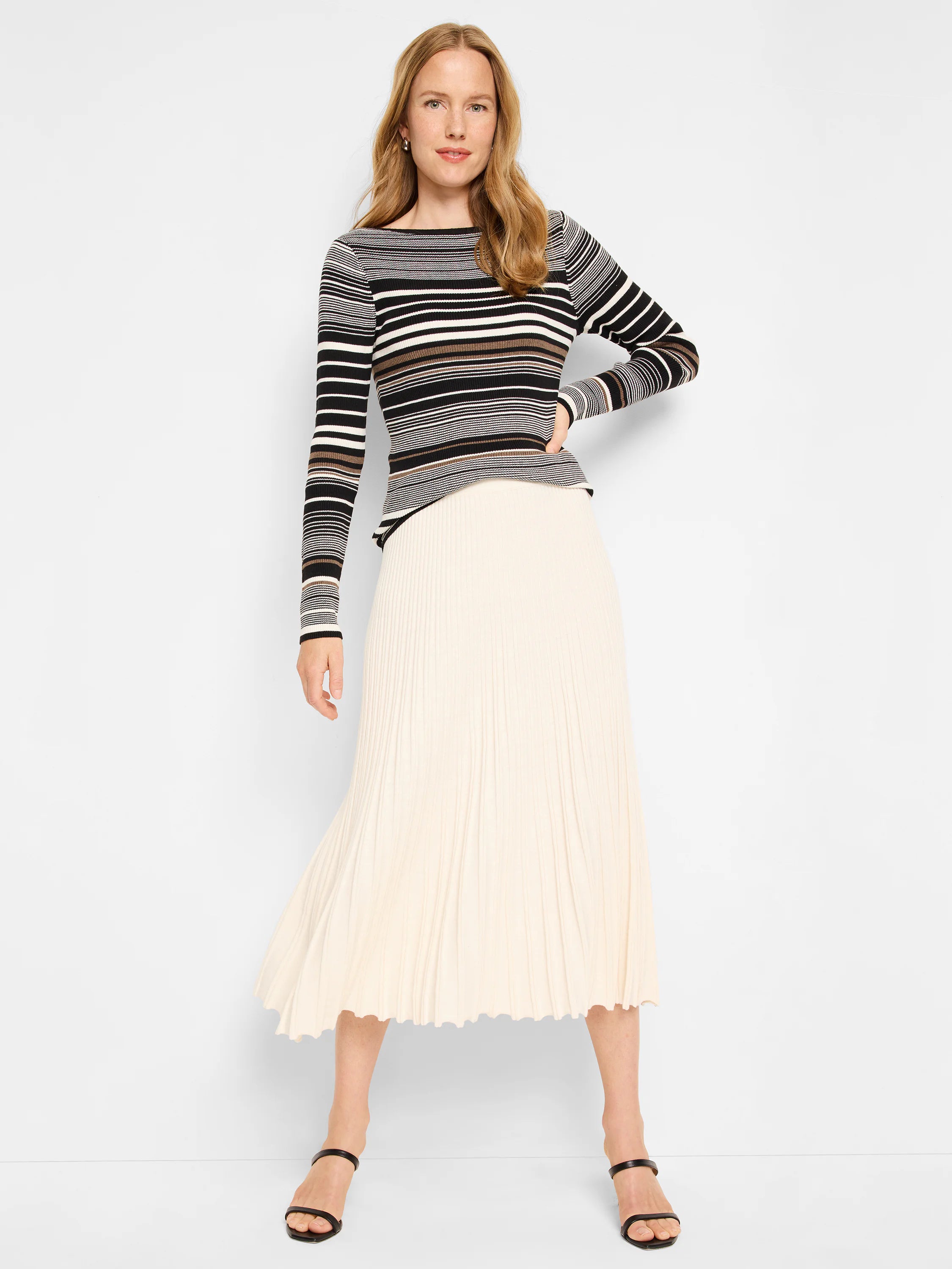 Black, white, and brown striped ribbed sweater tee; long sleeves. Off-white pleated midi skirt.