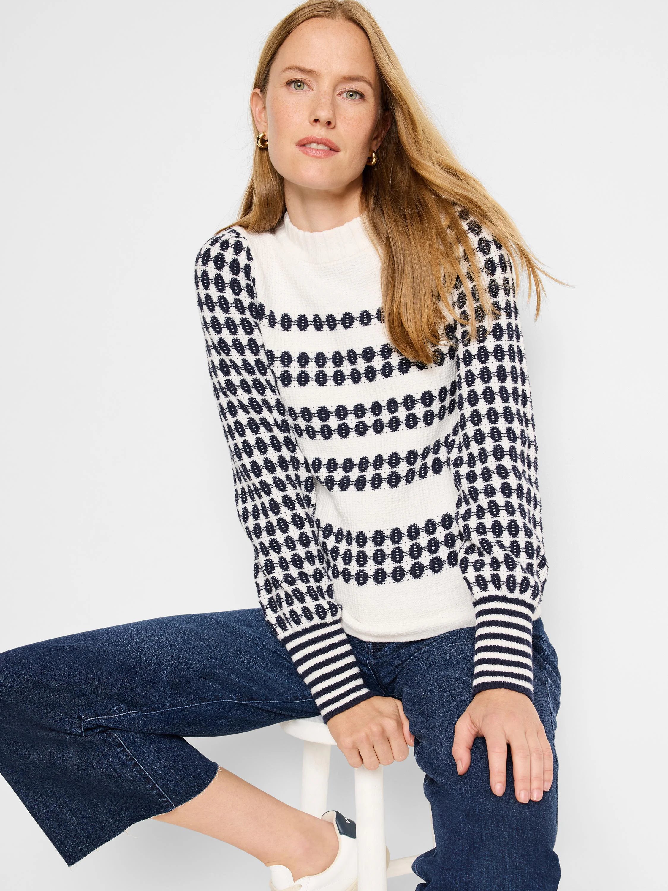Cream waffle-knit sweater with navy horizontal stripes and pattern on sleeves. Navy and cream striped cuffs.